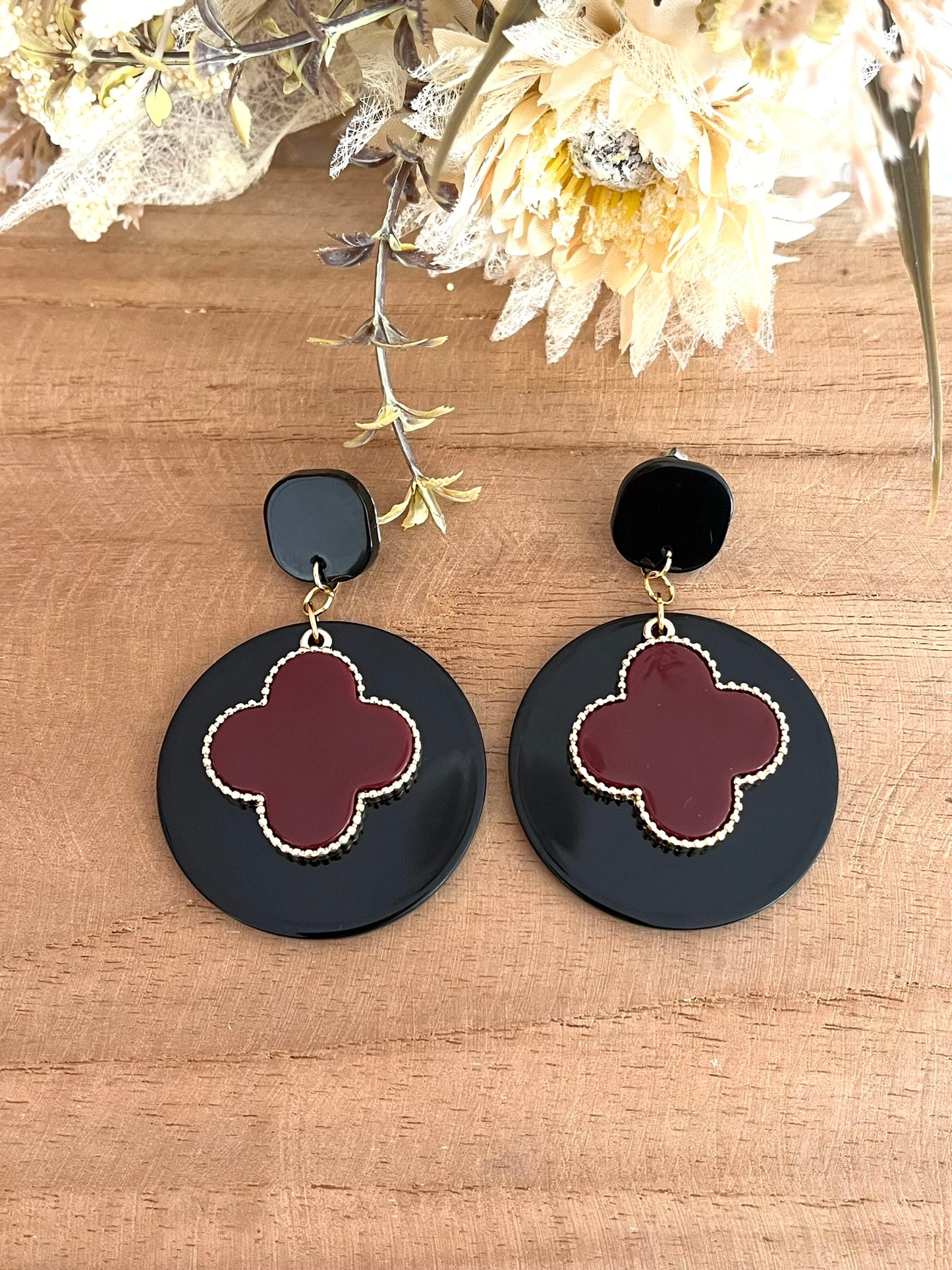 Boucles d'oreilles fantaisie faites main.
clous d'oreilles carrés en acrylique noir, pendentifs ronds en acrylique noir. Trèfle bordeaux et doré.
Bijou fantaisie fait main.