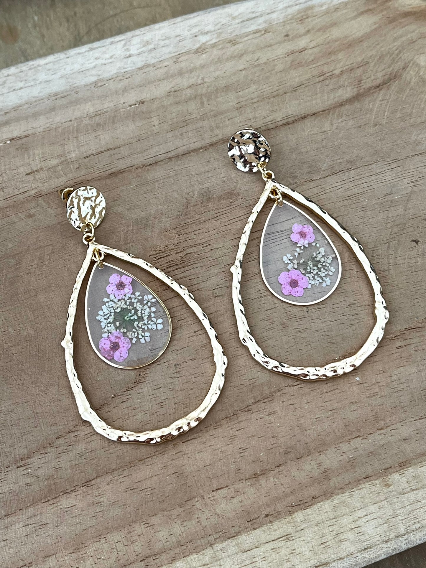 Clous d'oreilles ronds martelés dorés, grands pendentifs goutte doré, pendentifs goutte en résine avec fleurs séchées rose.
Bijou fantaisie fait main.