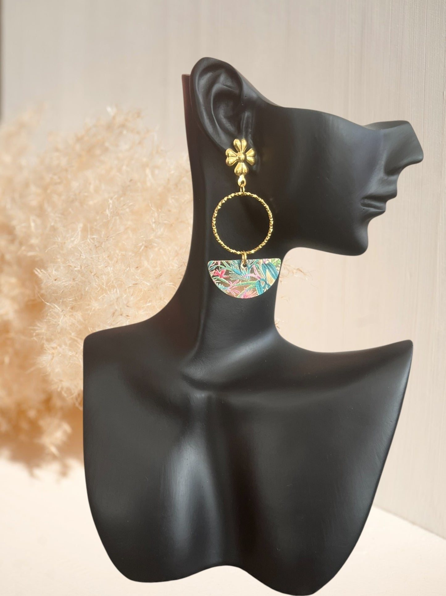 Boucles d'oreilles fantaisie faites main en acier inoxydable doré.
Clous d'oreilles fleur, anneaux ronds ciselés, pendentifs demi-lune imprimé de feuilles tropicales rose et vert.
Bijou fantaisie fait main.