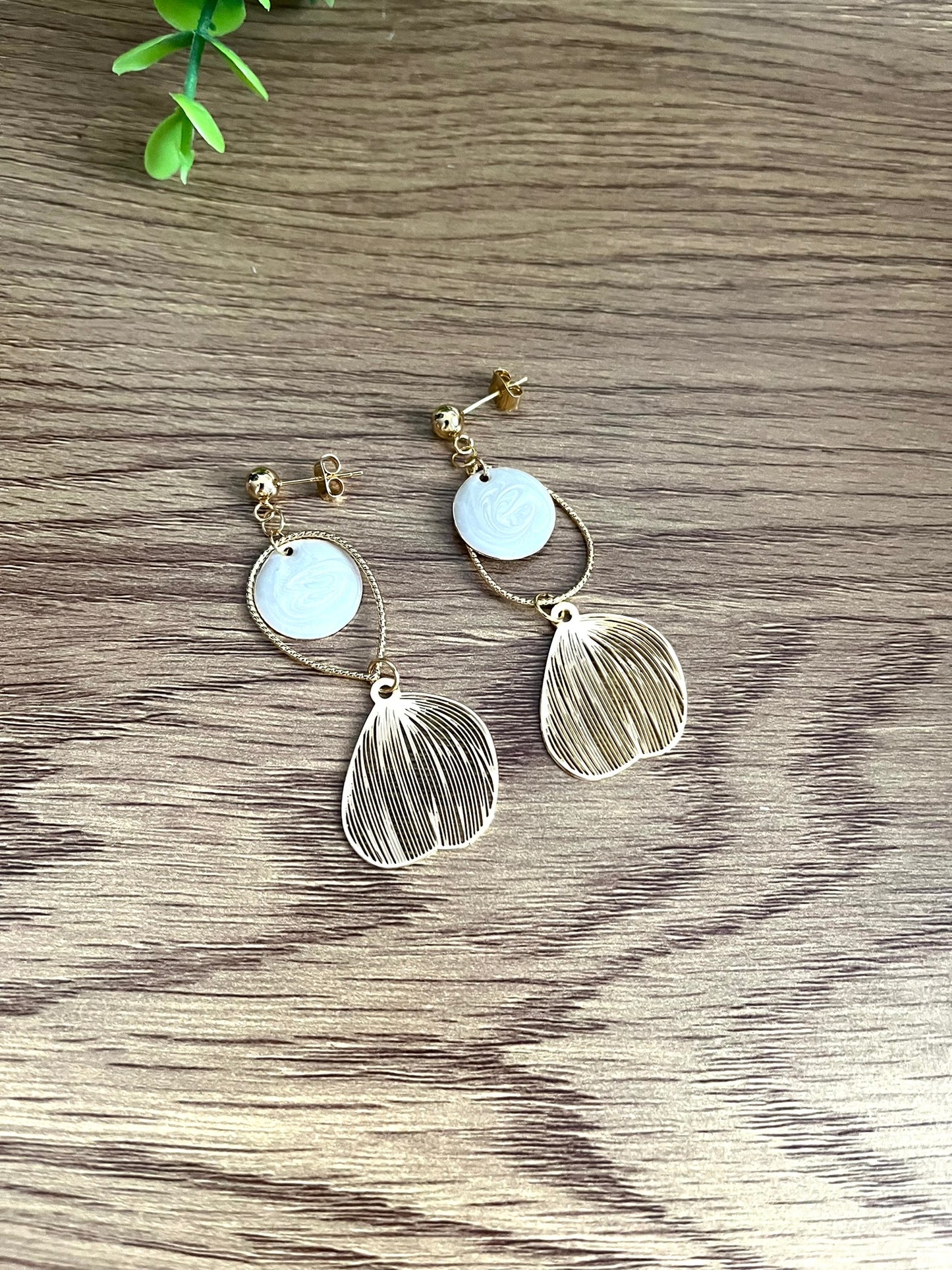 Boucles d'oreilles fantaisie fait main.
Clous d'oreilles doré, gouttes ciselées et estampes feuille en laiton doré à l'or fin 18k. Sequins ronds blanc nacré.
Bijou fantaisie fait main.