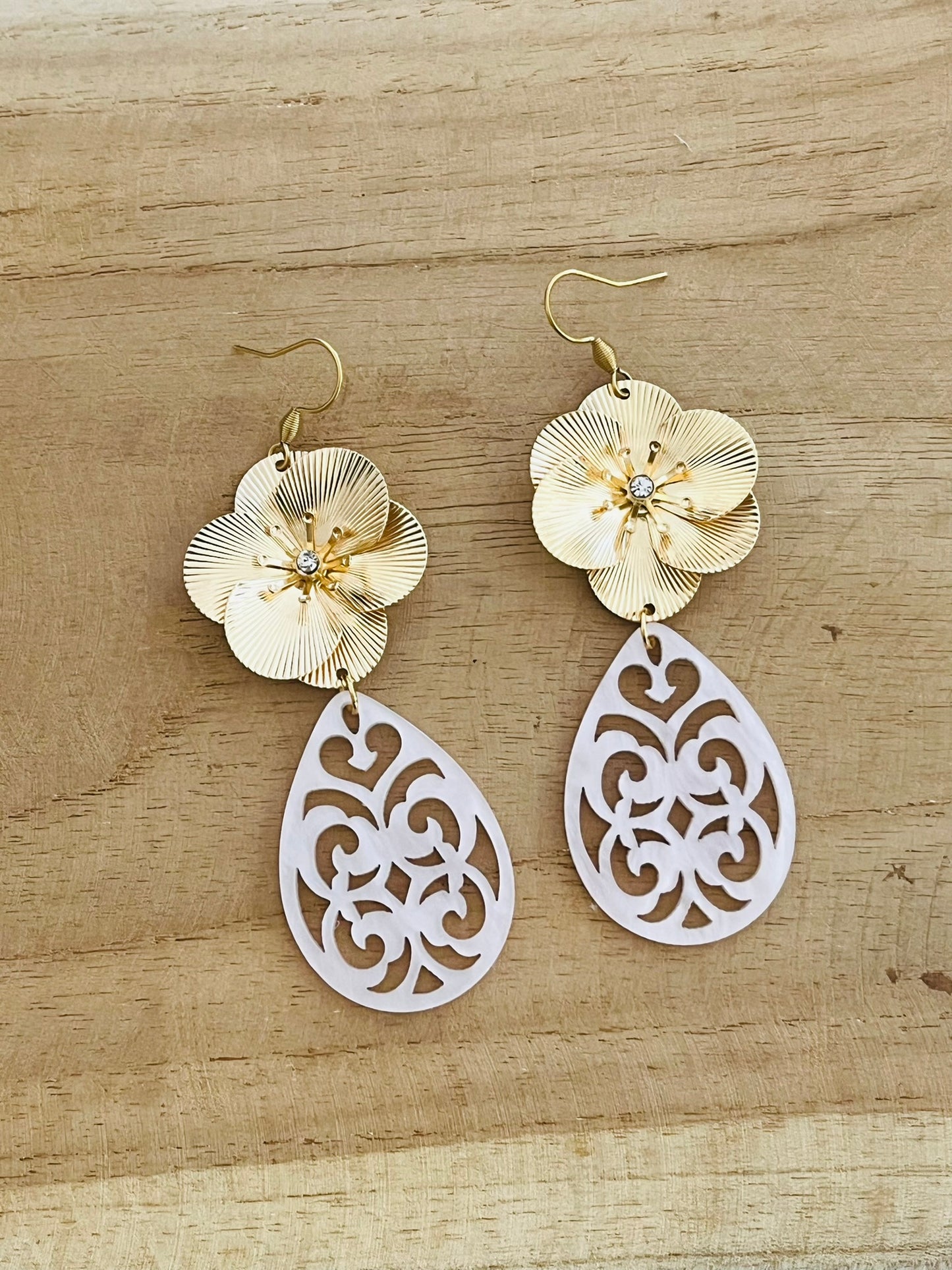 Boucles d'oreilles fantaisie pendantes style baroque. Grosse fleur dorée et pendentif goutte ajourée en acrylique rose pâle.
Bijou fantaisie fait main.