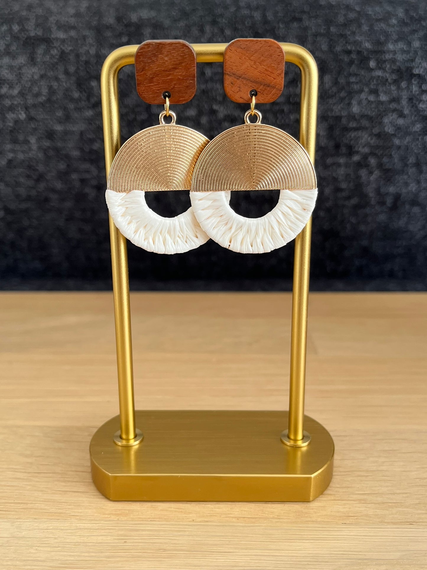 Boucles d'oreilles fantaisie fait main.
Boucles d'oreilles style ethnique rondes en laiton doré et raphia écru.
Clous d'oreilles carrés en bois de noyer.
Bijou fait main.