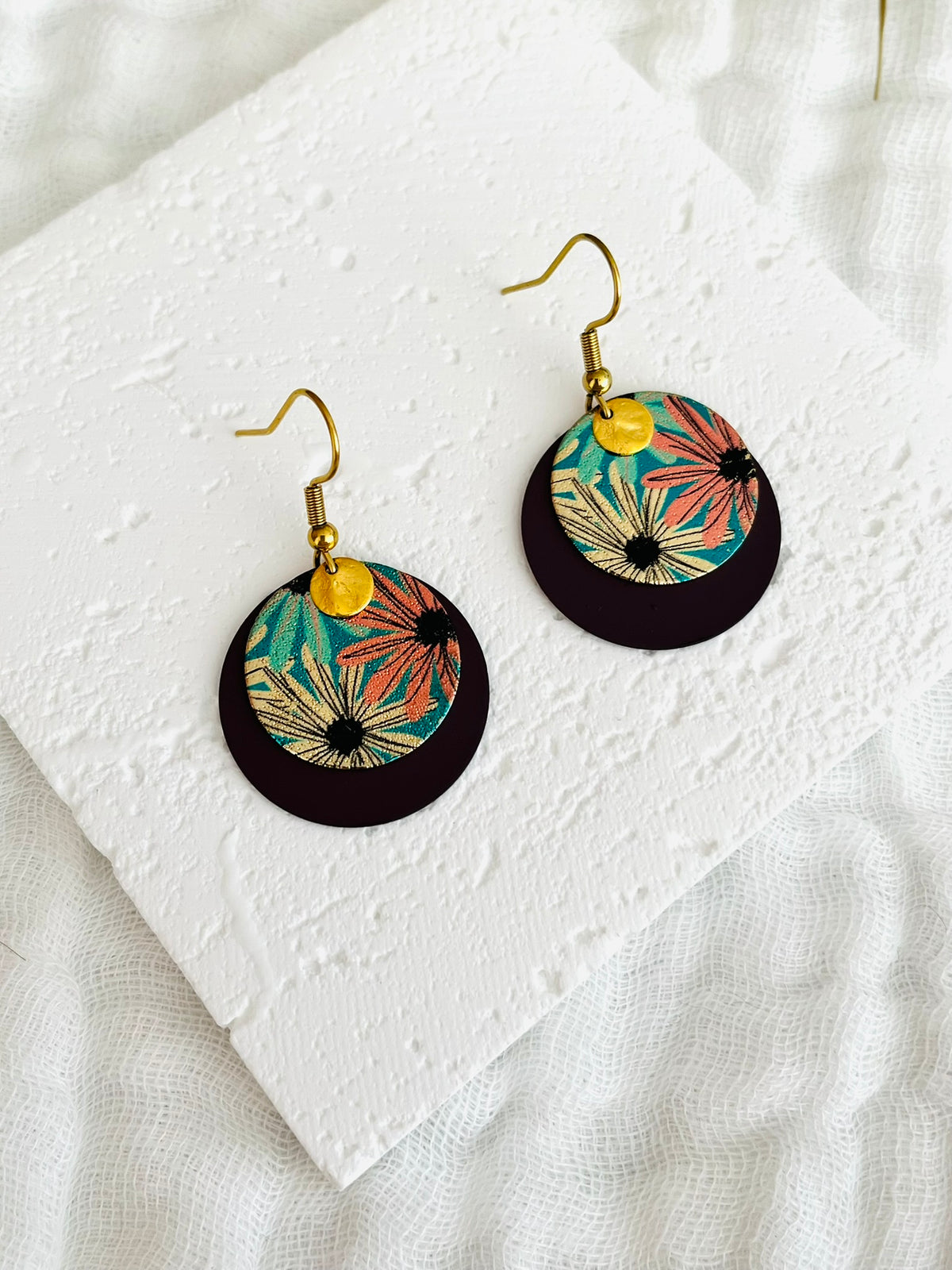 Boucles d'oreilles fantaisie fait main.
Crochets d'oreilles en acier inoxydable doré; pendentif disque rond couleur prune, sequin rond pailleté motif fleur doré, turquoise, rose, pampille ronde froissée doré.
Bijou fait main.