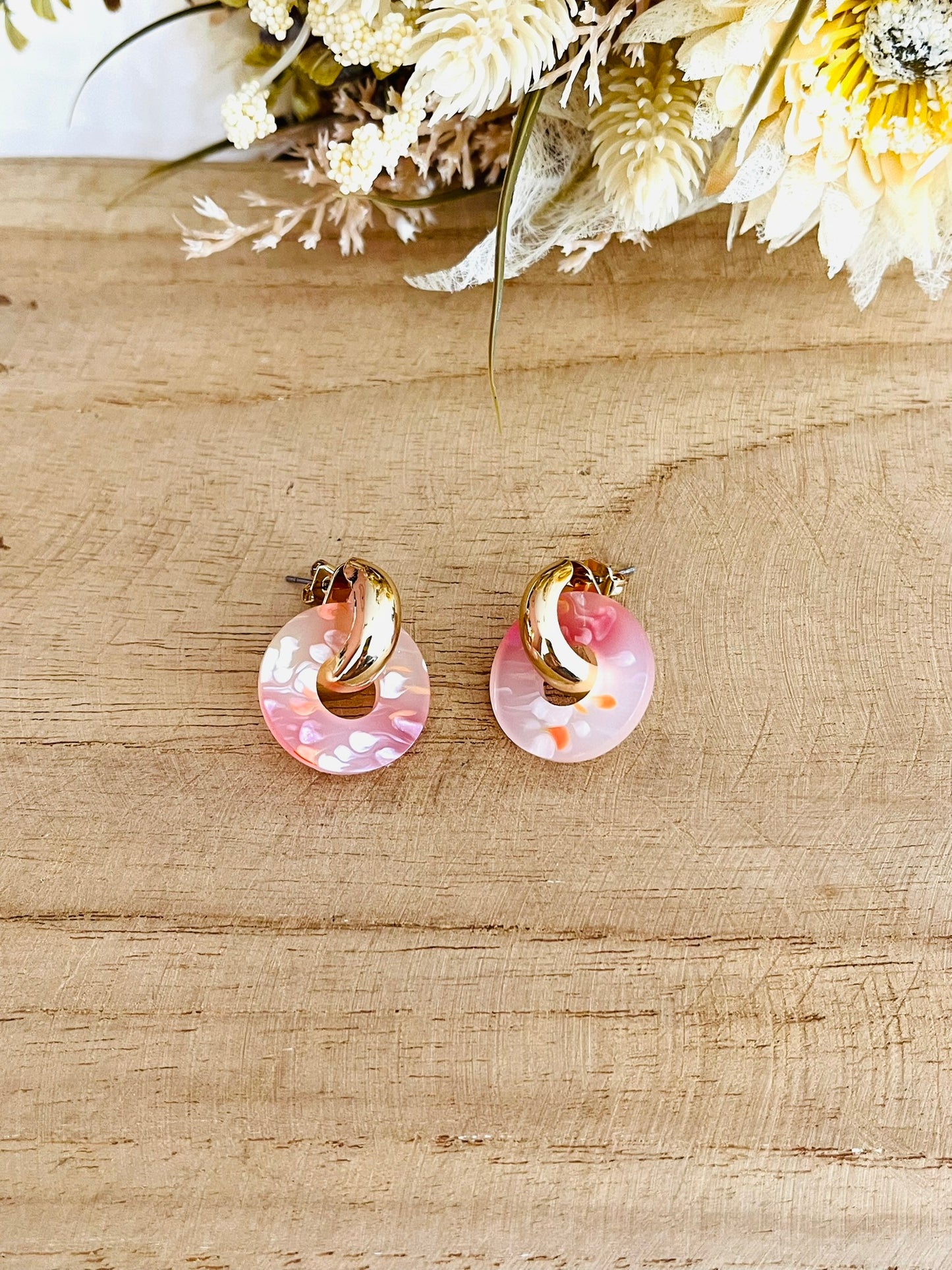 Boucles d'oreilles à clous style créoles bombées dorées.
Pendentifs donut en acrylique.
Boucles d'oreilles fantaisie fait main.
