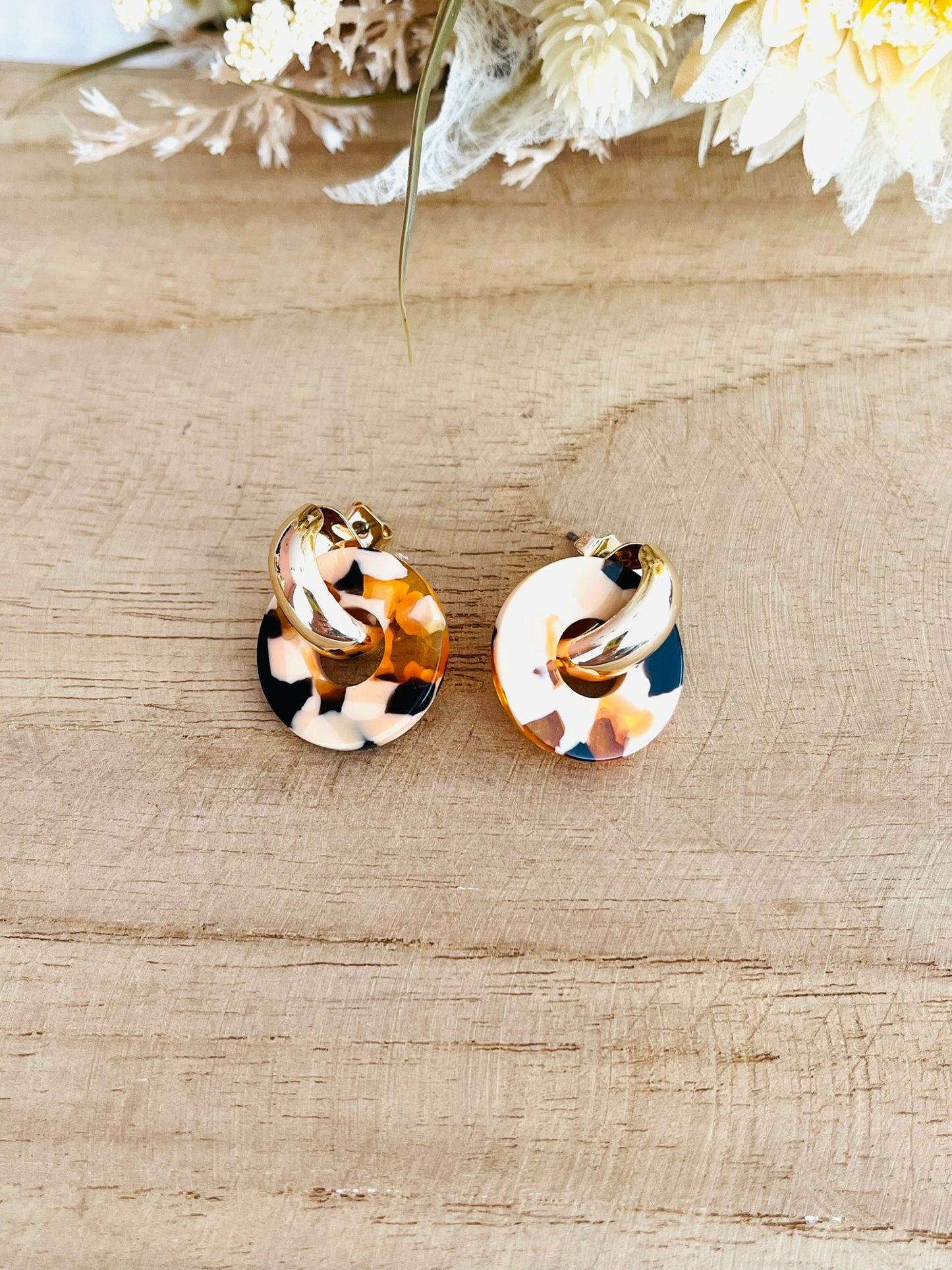 Boucles d'oreilles à clous style créoles bombées dorées.
Pendentifs donut en acrylique.
Boucles d'oreilles fantaisie fait main.