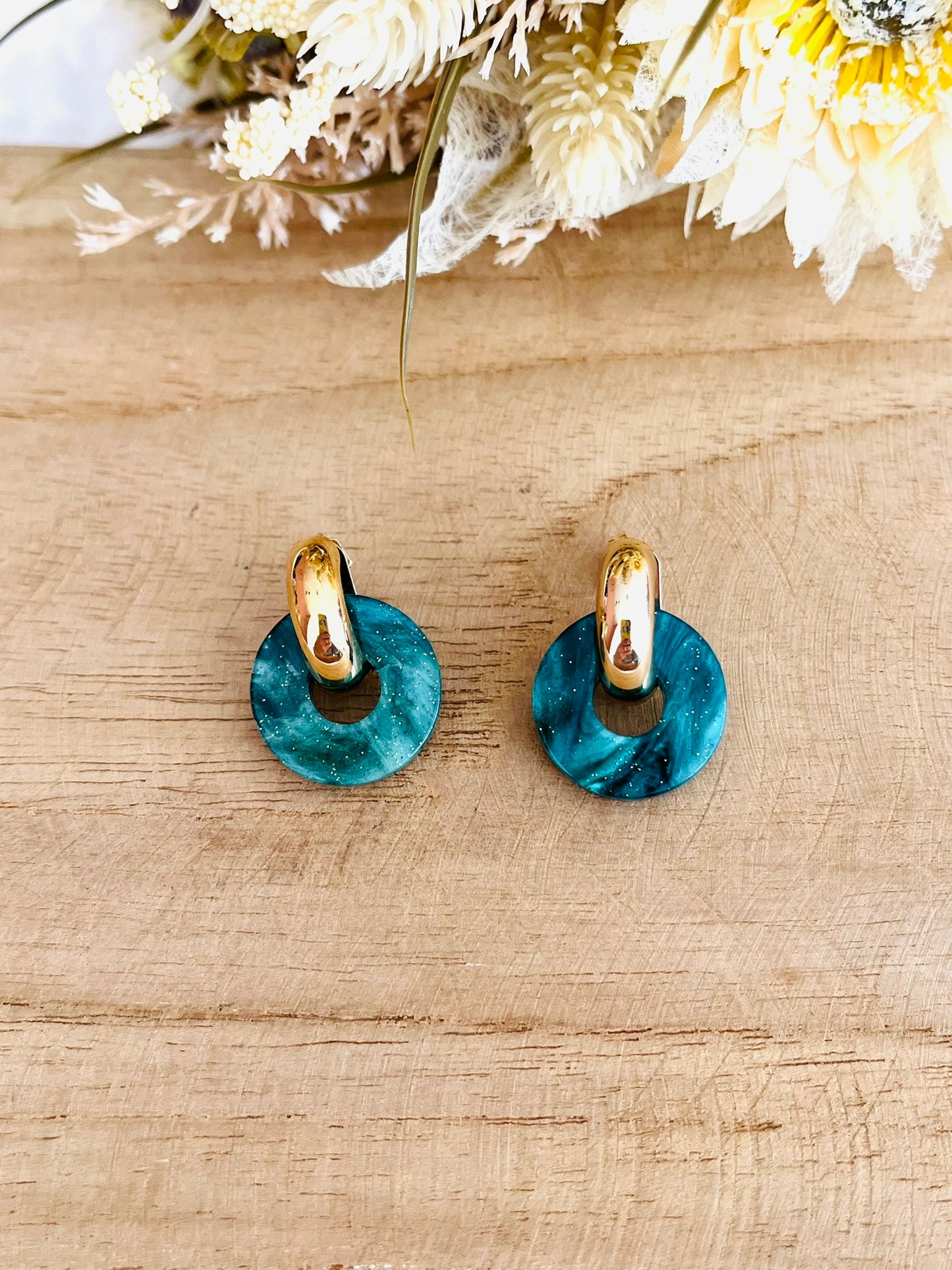 Boucles d'oreilles à clous style créoles bombées dorées.
Pendentifs donut en acrylique.
Boucles d'oreilles fantaisie fait main.
