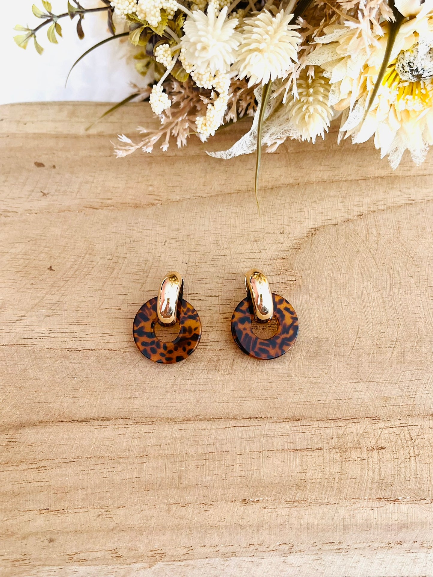 Boucles d'oreilles à clous style créoles bombées dorées.
Pendentifs donut en acrylique.
Boucles d'oreilles fantaisie fait main.