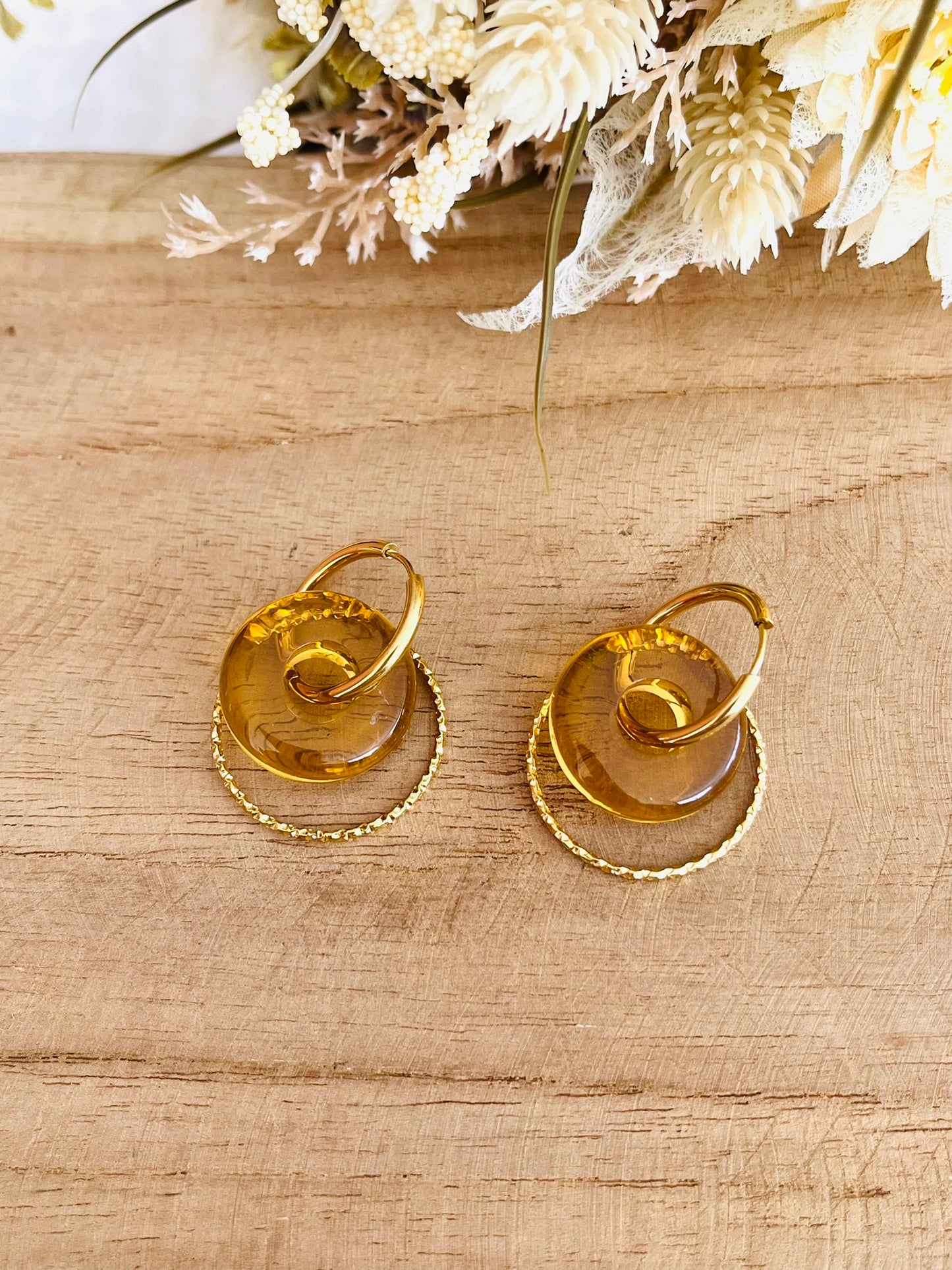 Boucles d'oreilles fantaisie fait main.
Créoles rondes en acier inoxydable doré avec pendentif donut en résine jaune translucide.