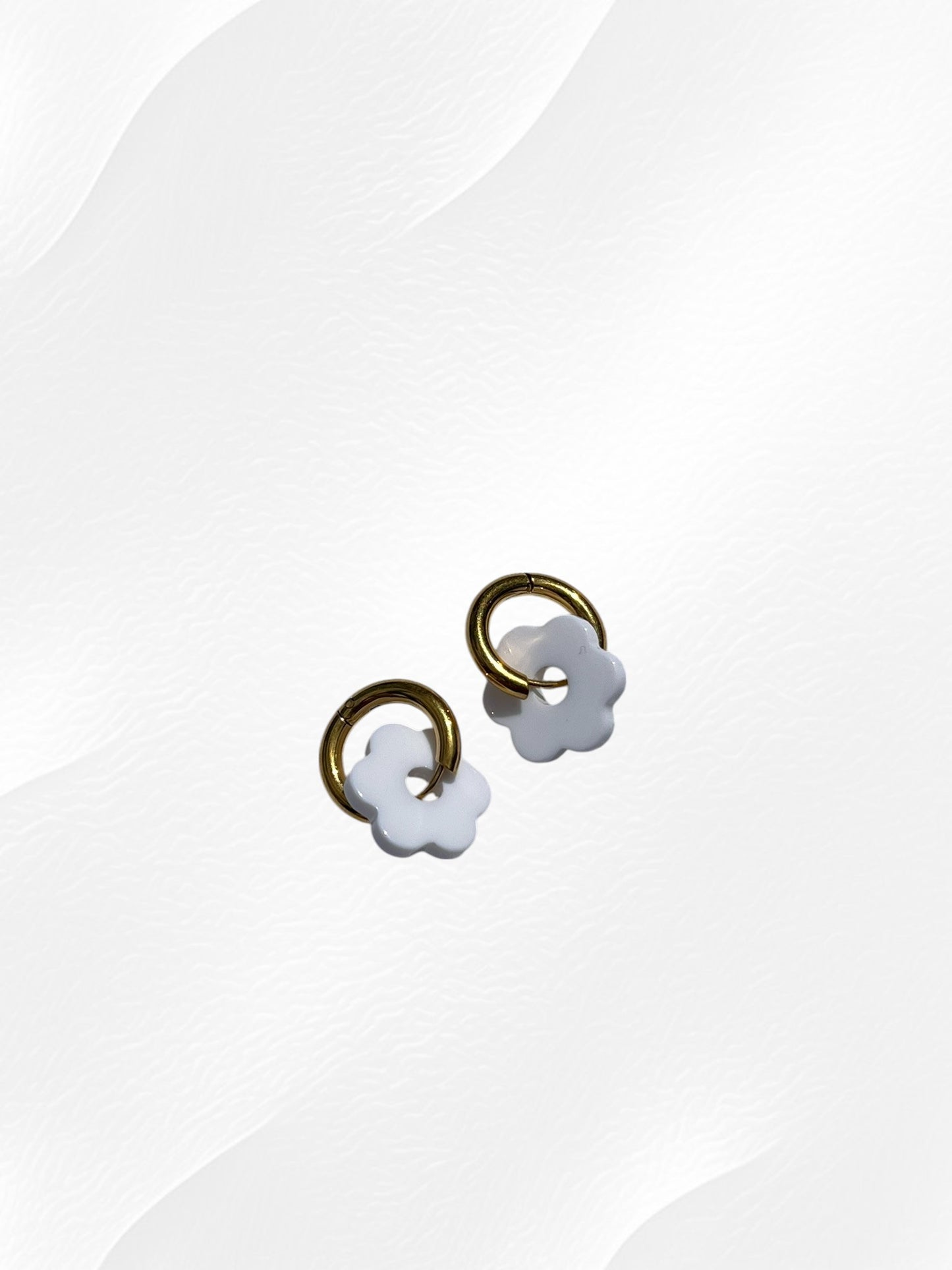 Boucles d'oreilles créoles adaptées pour les enfants à partir de 6 ans.
Créoles en acier inoxydable doré de 15mm.
Petites fleurs blanches en acrylique.