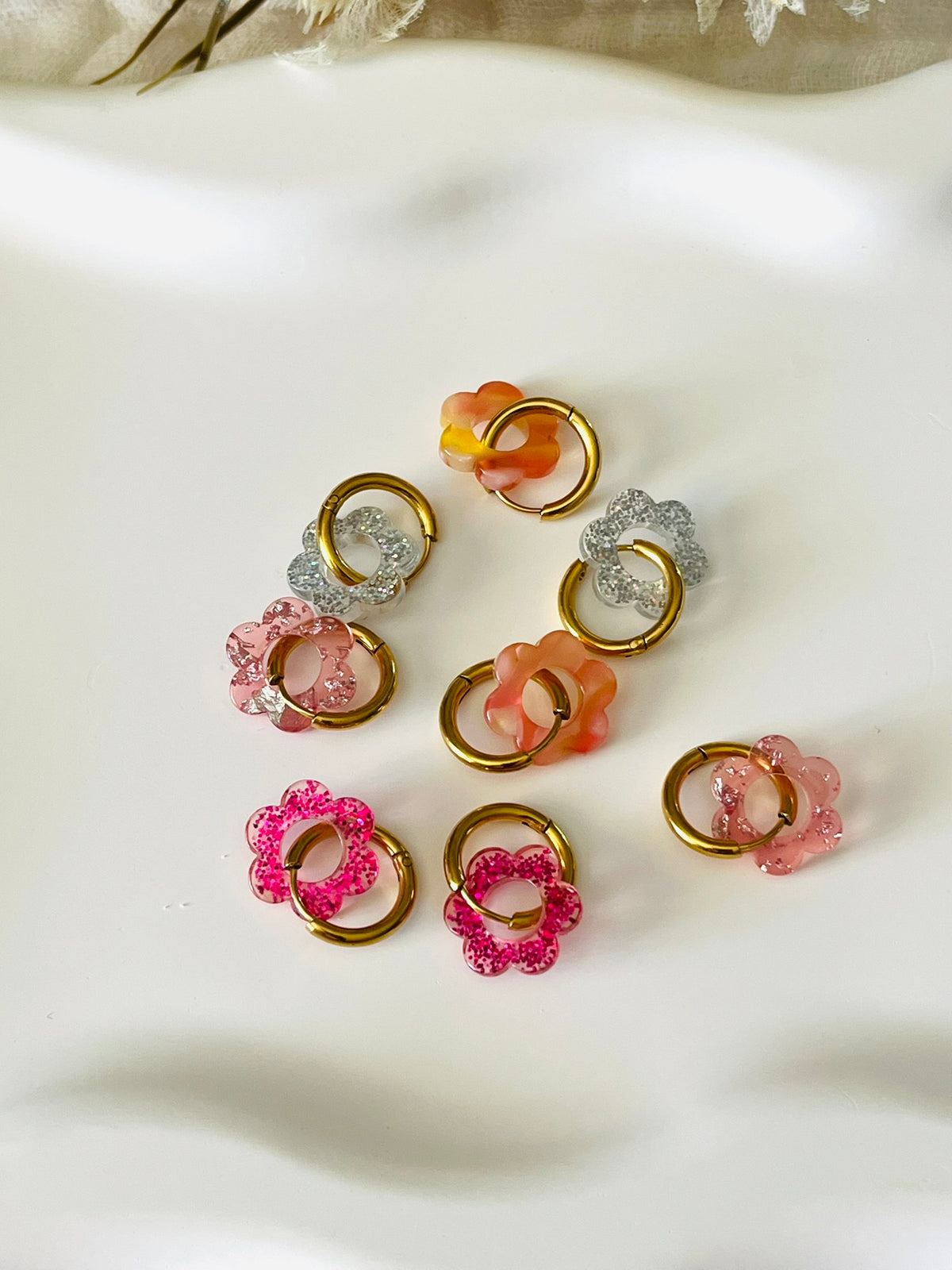 Boucles d'oreilles créoles adaptées pour les enfants à partir de 6 ans.
Créoles en acier inoxydable doré de 15mm.
Petites fleurs transparentes pailletées en acrylique.