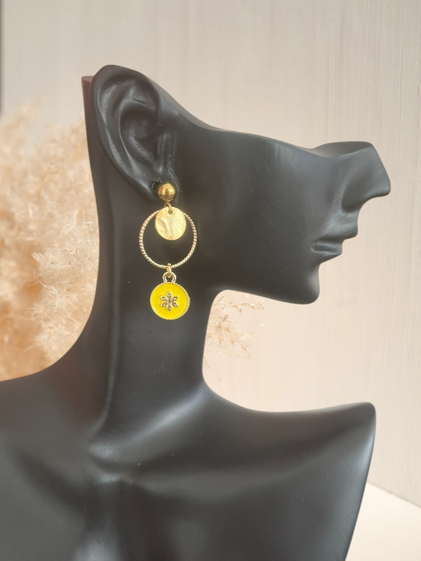 Boucles d'oreilles fantaisie dorées et résine époxy jaune.
Pendentif rond avec une fleur.
Bijou fantaisie fait main.