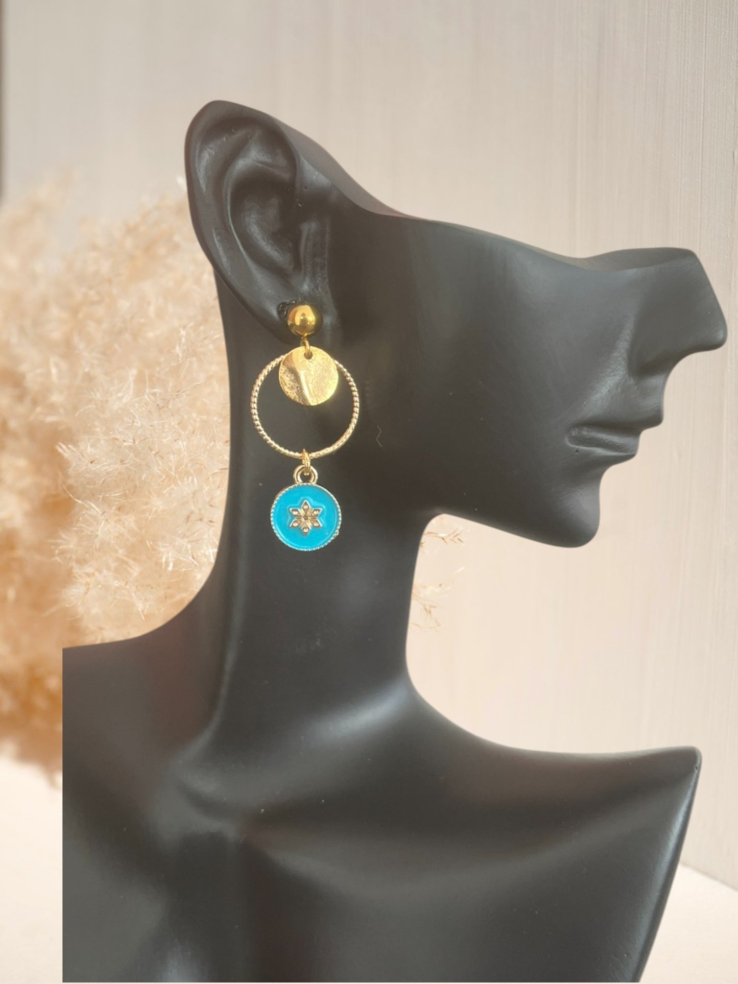 Boucles d'oreilles fantaisie dorées et résine époxy turquoise.
Pendentif rond avec une fleur.
Bijou fantaisie fait main.