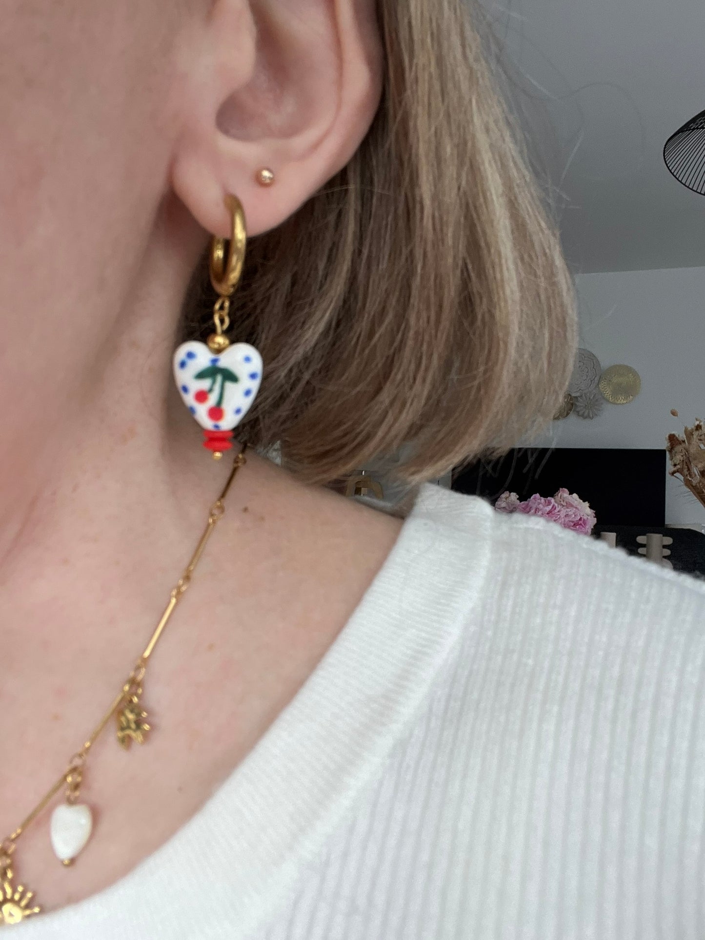 Boucles d'oreilles fantaisie fait main.
Créoles rondes en acier inoxydable doré. Perles coeur en céramique blanc avec motif cerise rouge et pois bleus.
Bijou fait main.