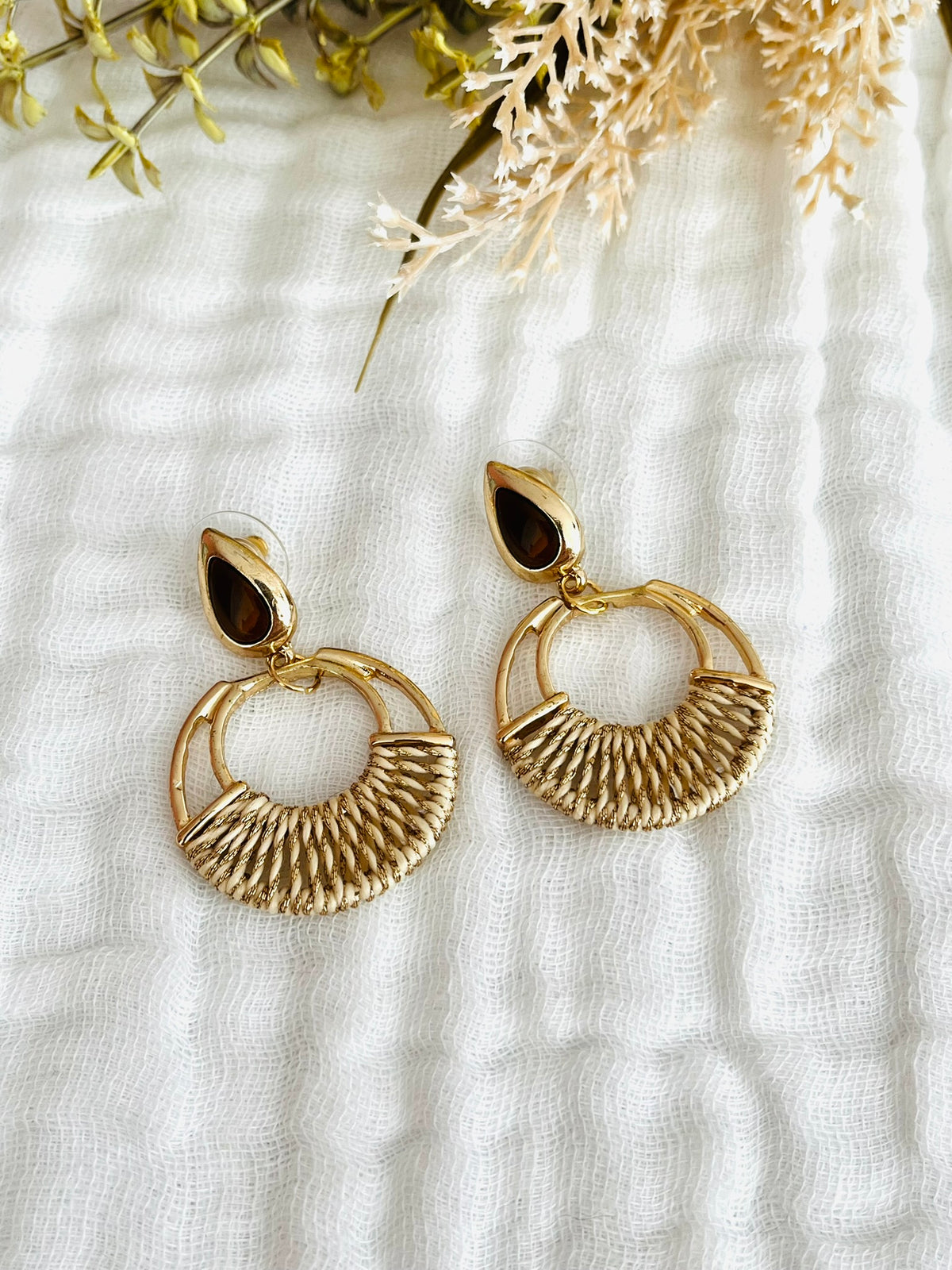 Boucles d'oreilles fantaisie fait main.
Clous d'oreilles goutte doré avec un cabochon marron foncé.
Pendentif rond doré avec un tissage de file beige et doré.
Bijou fantaisie fait main.