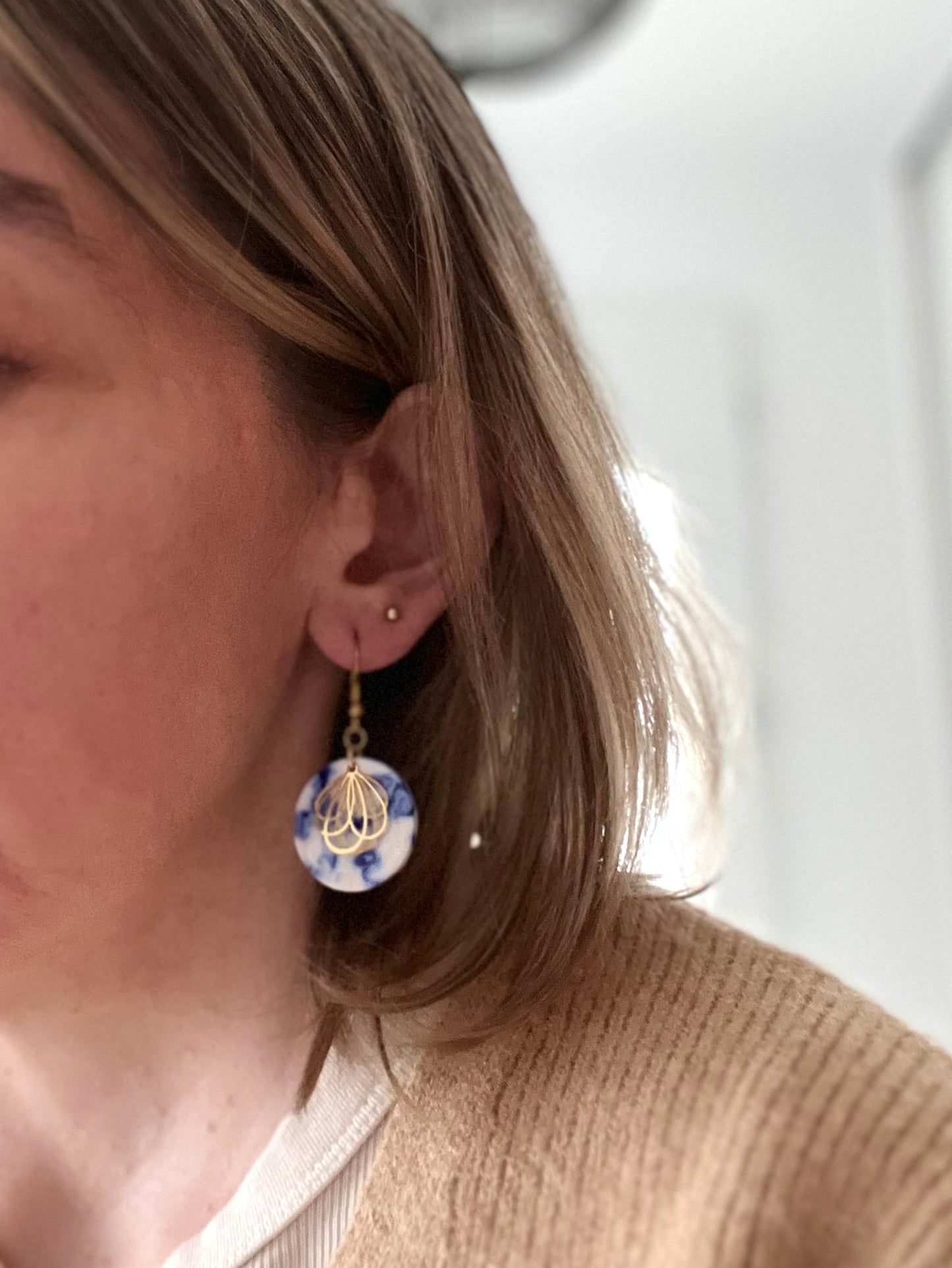 Boucles d'oreilles fantaisie fait main.
Crochets en acier inox doré. Pendentifs ronds en acrylique blanc marbré bleu. Estampe pétale de fleur en acier inox doré.
Bijou fantaisie fait main.