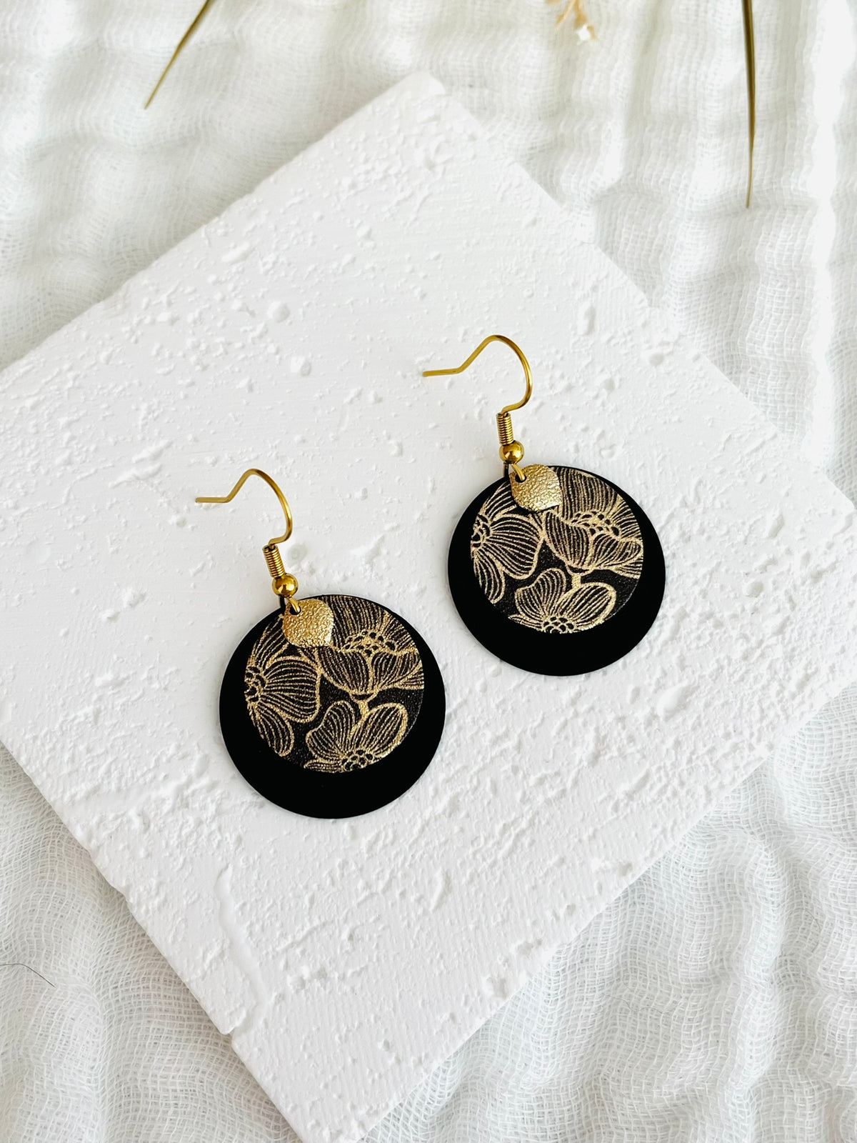 Boucles d'oreilles fantaisie fait main.
Crochets d'oreilles en acier inox doré; pendentifs disque noir, sequins ronds motif fleur de lotus noir et doré pailleté; pampille goutte diamantée doré.
Bijou fait main