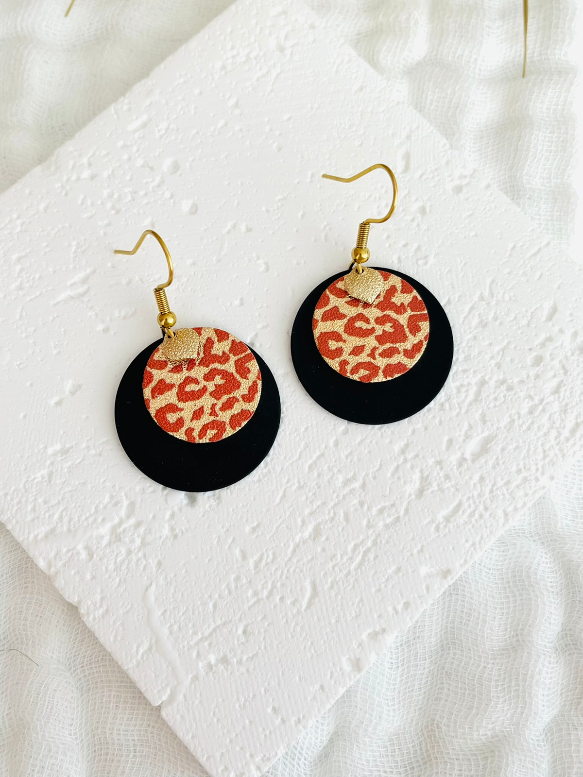 Boucles d'oreilles fantaisie fait main.
Crochets d'oreilles en acier inox doré. Pendentif disque rond noir, sequin rond imprimé léopard pailleté terracotta et doré, pampille goutte diamanté doré.
Bijou fait main.