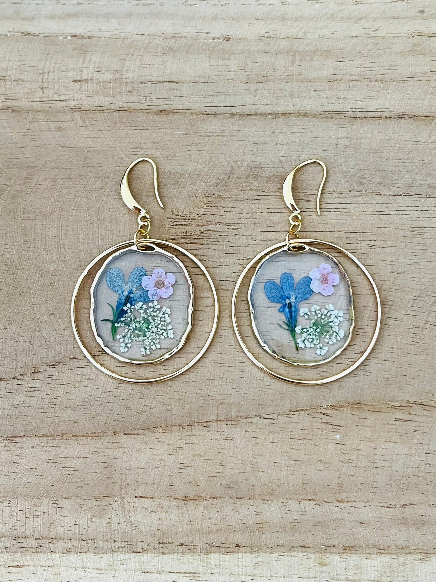 Boucles d'oreilles fantaisie fait main.
Crochets d'oreilles en laiton or 18k.
Anneaux ronds fermés en laiton or 18k
Pendentifs ronds fleurs séchées bleu.
Bijou fantaisie fait main.