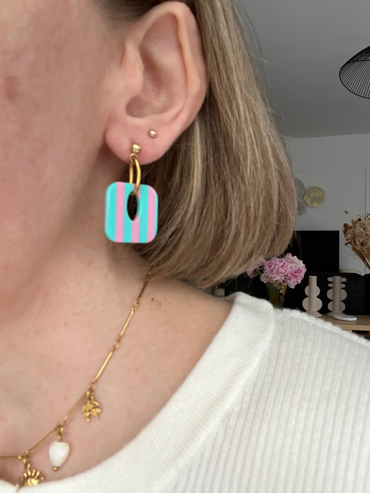 Boucles d'oreilles fantaisie fait main.
Clous d'oreilles en acier inoxydable doré. Pendentif carré en acrylique rayés.
Bijou fait main