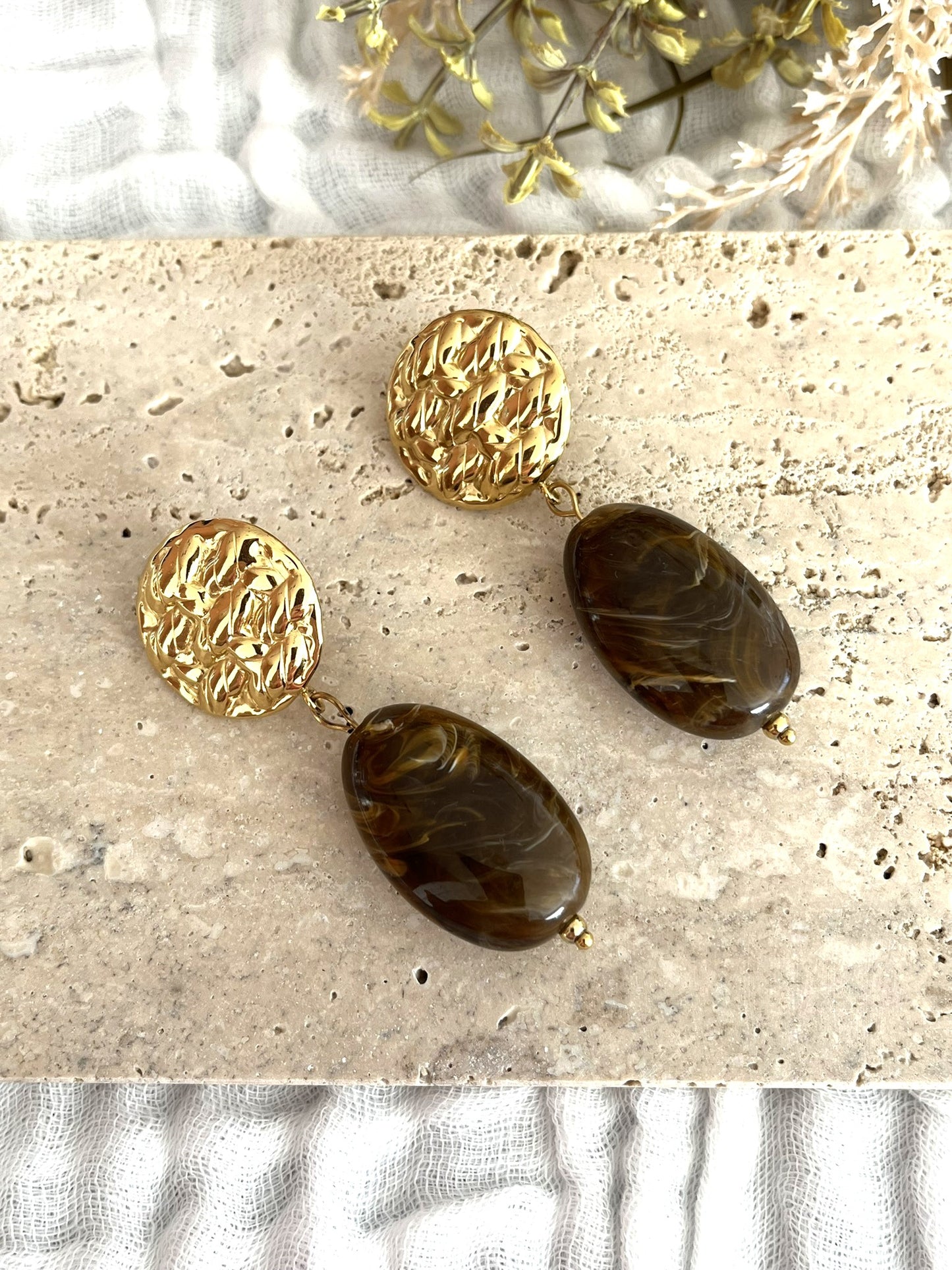 Boucles d'oreilles fantaisie fait main.
Clous d'oreilles ronds martelés en acier inoxydable doré.
Perle ovale en résine rouge marbré.
Bijou fantaisie fait main.