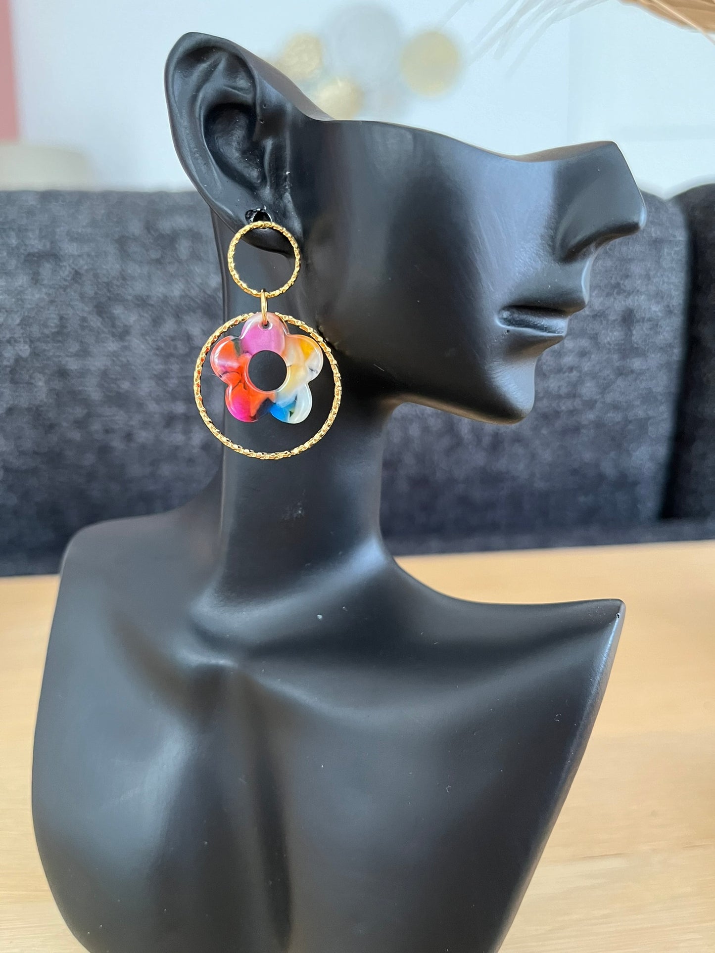Boucles d'oreilles fantaisie fait main.
Clous d'oreilles ronds en acier inox doré, anneau fermé ciselé en acier doré, fleur multicolore en acrylique.
Bijou fantaisie fait main.