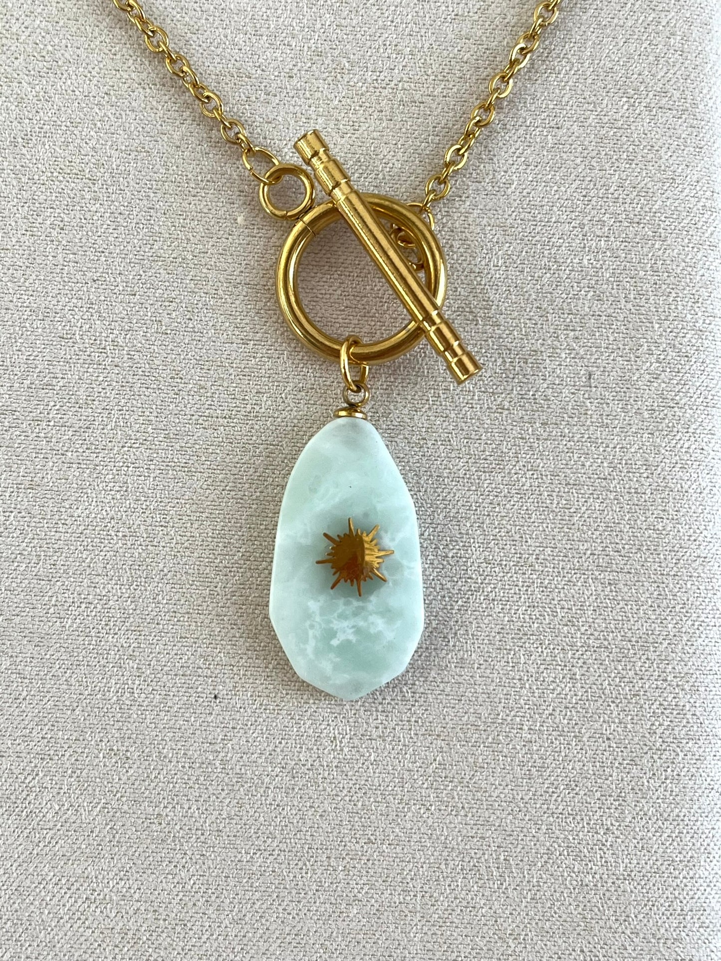 Collier fantaisie fait main en acier inoxydable doré.
Pendentif en pierre couleur vert d'eau.
Bijou fantaisie fait main.