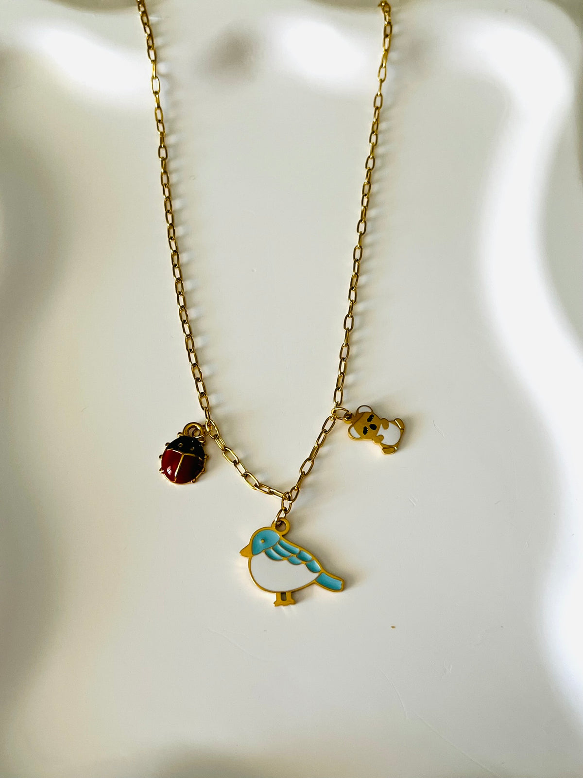 Collier adapté pour les enfants à partir de 6 ans.
Collier en acier inoxydable doré, hypoallergénique.
Breloque oiseau bleu et blanc, coccinelle rouge, koala doré et blanc.