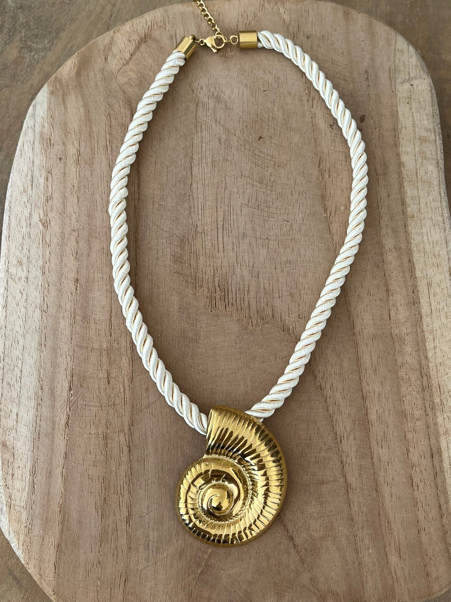 Collier corde tressée écru avec pendentif coquillage en acier inoxydable doré.
Bijou fantaisie fait main.