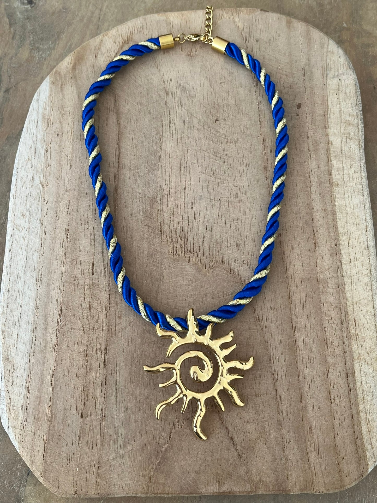Collier corde tressée bleu et doré avec pendentif soleil en acier inoxydable doré.
Bijou fantaisie fait main.