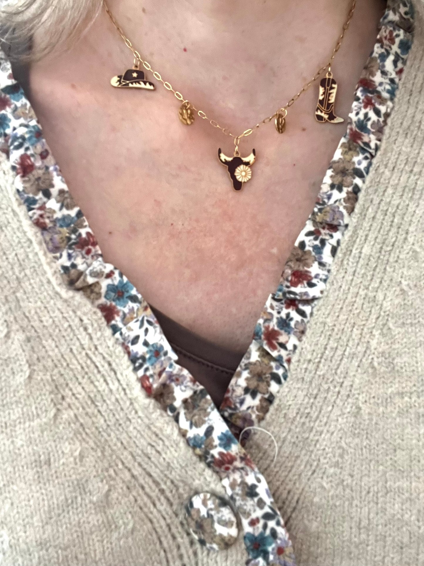 Collier fantaisie fait main.
Collier à breloques en acier inoxydable doré. Thème western, cow-boy. Charms en acier émaillé marron et beige: santiag, tête de buffle, chapeau de cow-boy.
Bijou fantaisie fait main.