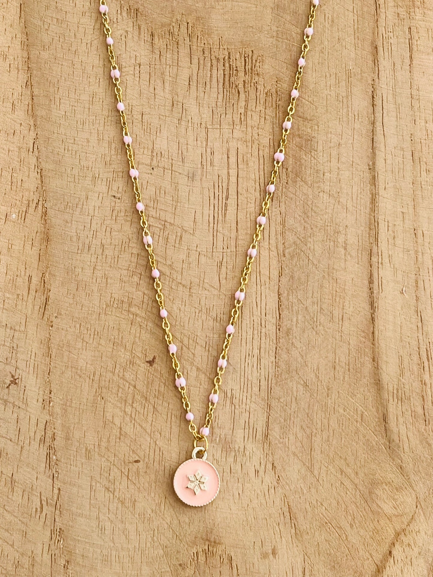 Collier fantaisie en acier inoxydable doré et résine époxy rose.
Pendentif rond avec une fleur.
Bijou fantaisie fait main.