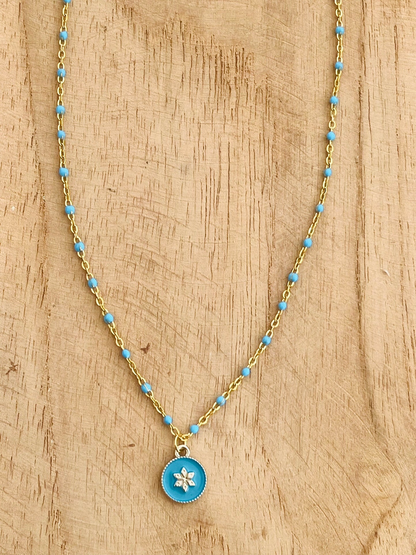 Collier fantaisie en acier inoxydable doré et résine époxy turquoise.
Pendentif rond avec une fleur.
Bijou fantaisie fait main.