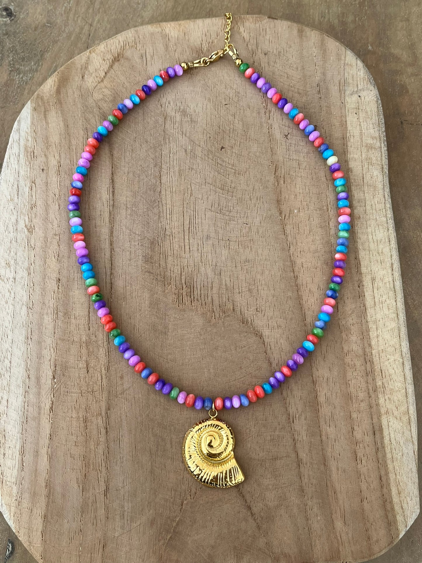 Collier fantaisie fait main.
Perles en coquillage violet multicolore, pendentif coquillage en acier inoxydable doré.
Bijou fantaisie fait main.