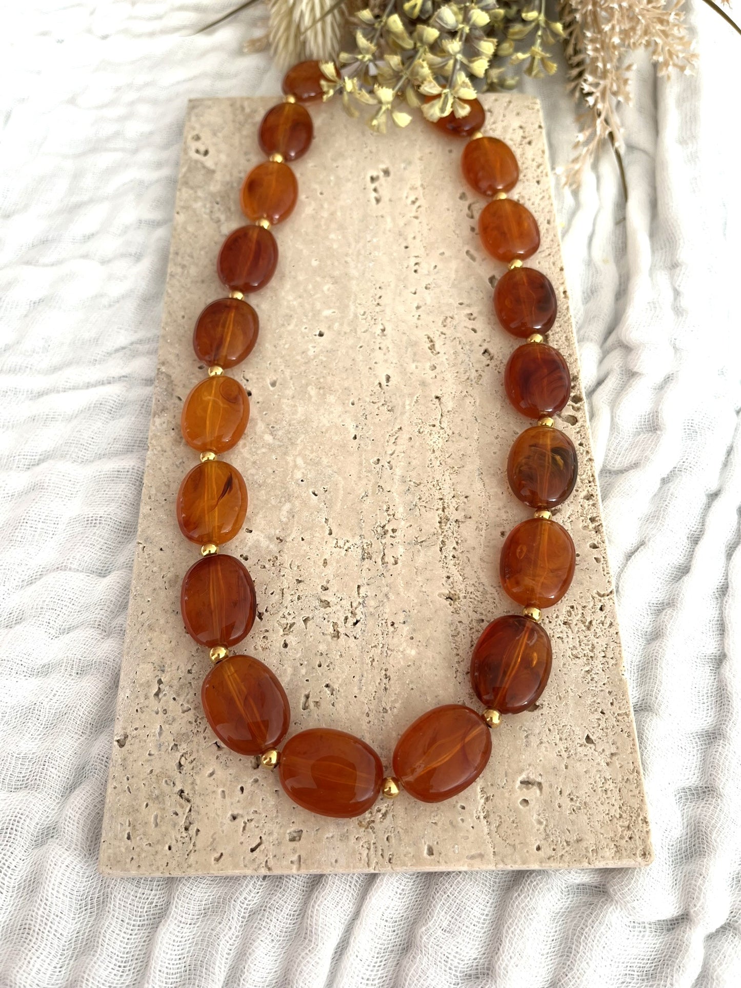 Collier fantaisie fait main.
Perles ovales en résine ambre marbré.
Petites perles intercalaires ronde en acier doré.
Bijou fantaisie fait main.