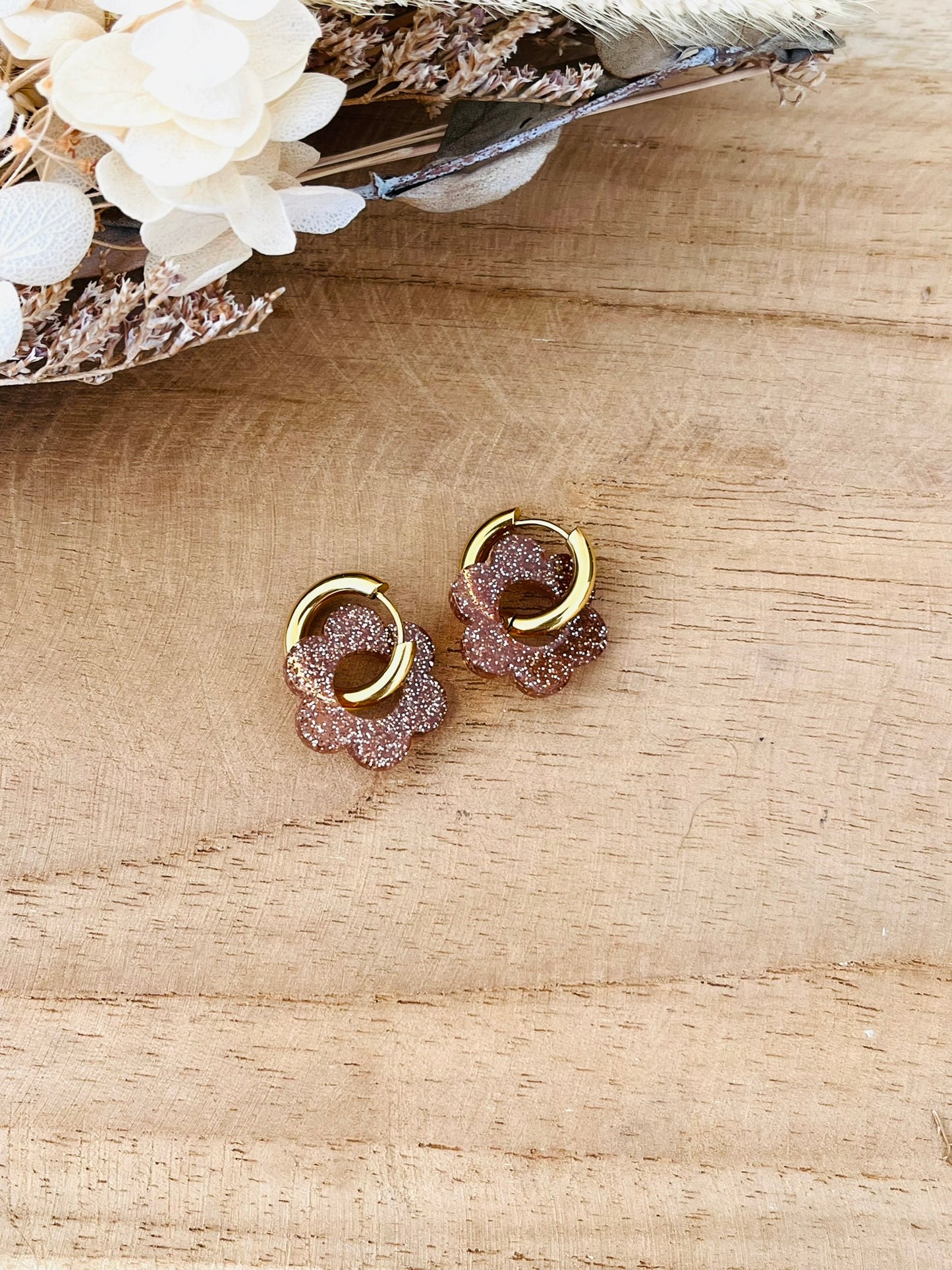 Boucles d'oreilles créoles fantaisie faites main.
Créoles en acier inoxydable de 15mm.
Fleur en acrylique de 18mm bronze pailleté.
Bijou fantaisie fait main.