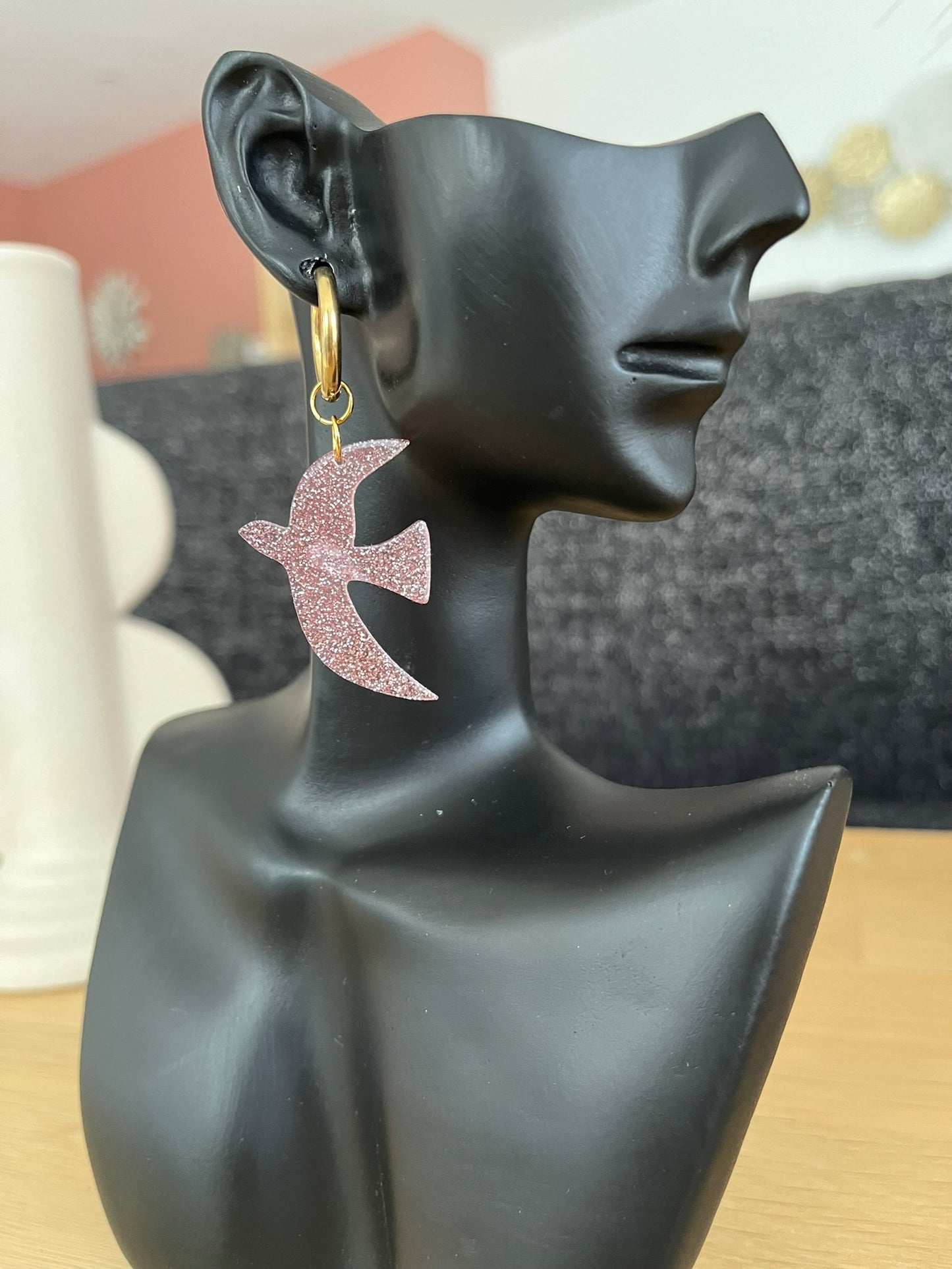 Boucles d'oreilles fantaisie fait main.
Créoles en acier inoxydable doré. Pendentifs hirondelle en acrylique rose pailleté.