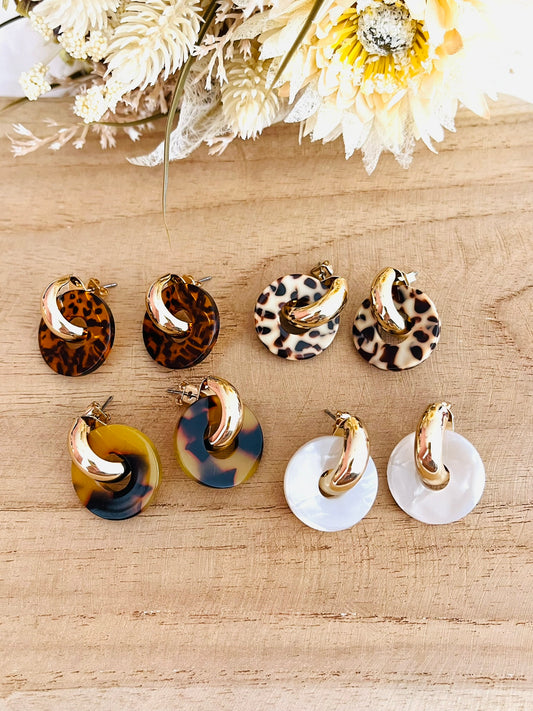 Boucles d'oreilles à clous style créoles bombées dorées.
Pendentifs donut en acrylique.
Boucles d'oreilles fantaisie fait main.