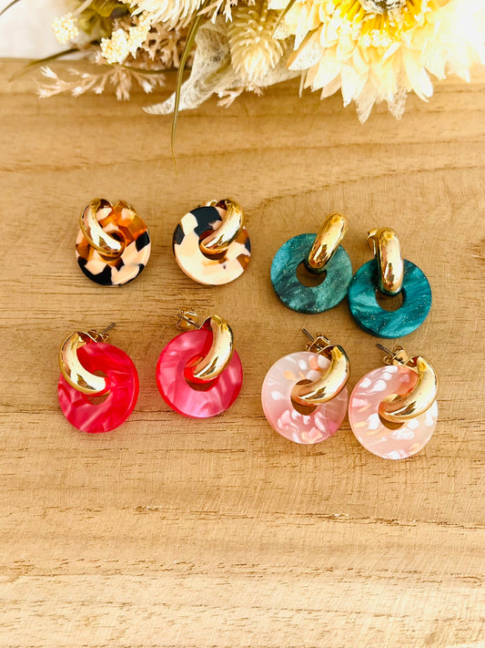 Boucles d'oreilles à clous style créoles bombées dorées.
Pendentifs donut en acrylique.
Boucles d'oreilles fantaisie fait main.