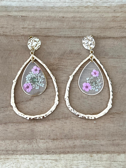 Boucles d'oreilles fantaisie fait main.
Clous d'oreilles ronds martelés dorés, grands pendentifs goutte doré, pendentifs goutte en résine avec fleurs séchées rose.
Bijou fantaisie fait main.