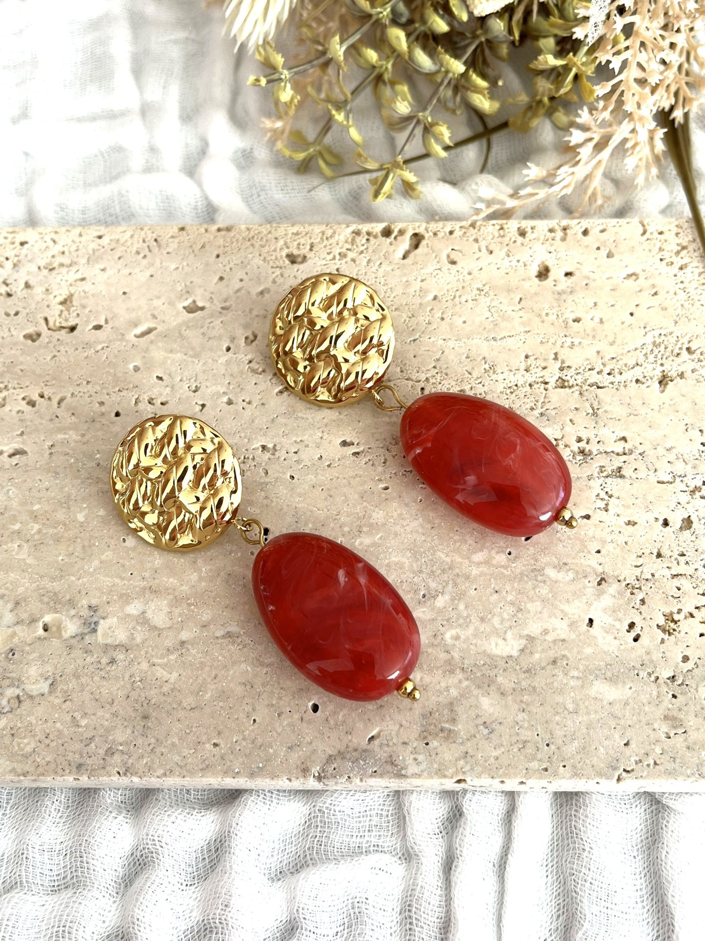 Boucles d'oreilles fantaisie fait main.
Clous d'oreilles ronds martelés en acier inoxydable doré.
Perle ovale en résine rouge marbré.
Bijou fantaisie fait main.