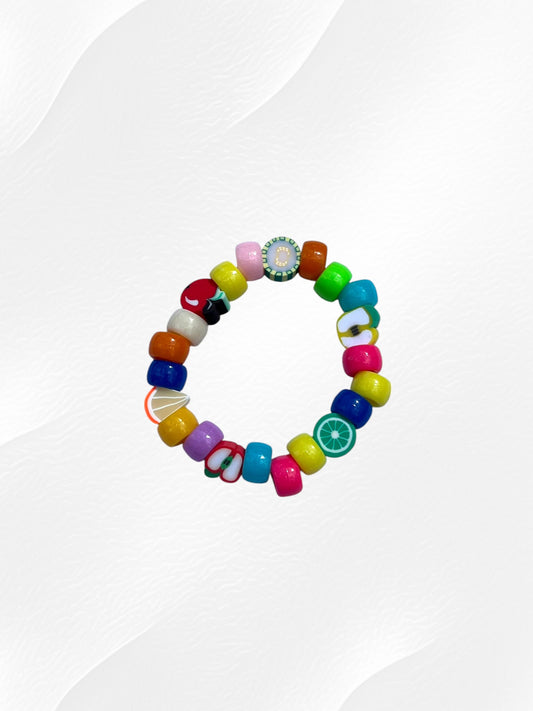 Bracelet pour enfant monté sur élastique.
Perles en acrylique multicolores fluo et perles fruits en argile polymère.