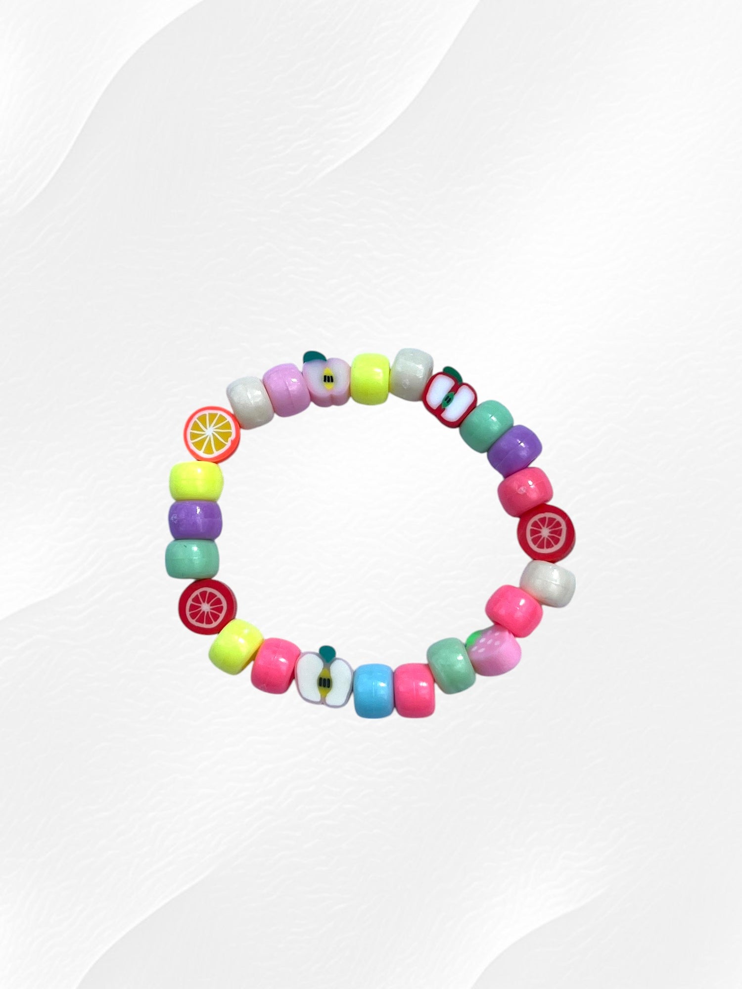 Bracelet pour enfant monté sur élastique.
Perles en acrylique multicolores pastel et perles fruits en argile polymère.