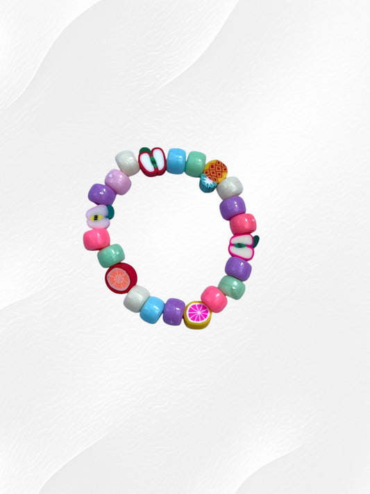 Bracelet pour enfant monté sur élastique.
Perles en acrylique multicolores pastel et perles fruits en argile polymère.