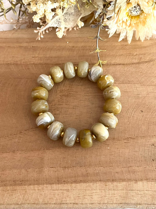 Bracelet élastique fait main.
Perles rondelles en résine kaki clair. Perles intercalaires rondes en acier inoxydable doré.
Bijou fantaisie fait main.