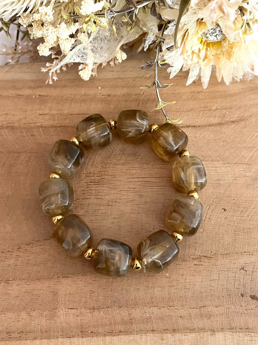 Bracelet élastique fait main.
Perles cube en résine marron glacé, perles intercalaires rondes en acier inoxydable doré.
Bijou fantaisie fait main.