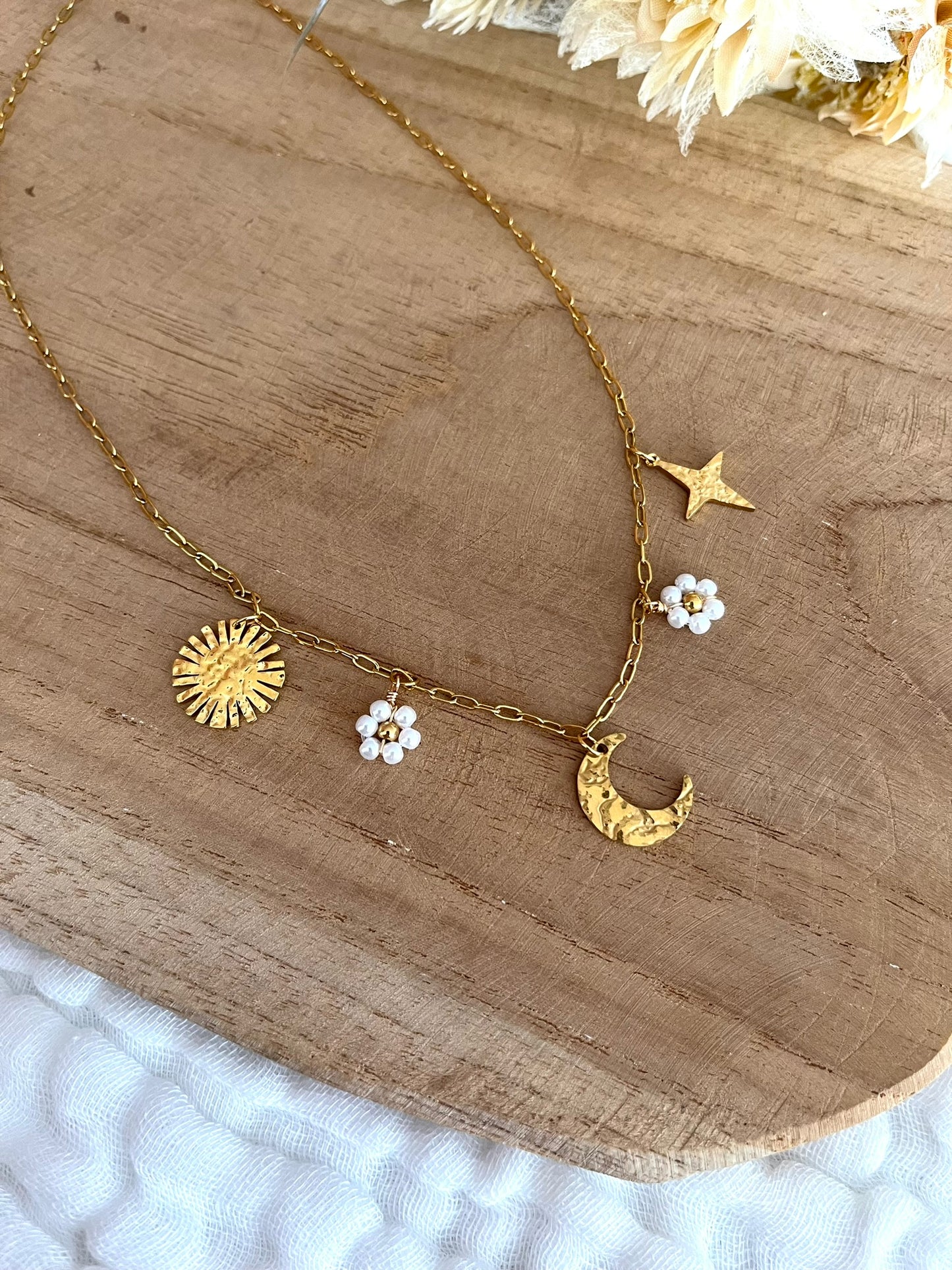 Collier fantaisie fait main.
Collier à breloques en acier inoxydable doré. Thème céleste. Charms en acier doré: lune, soleil, étoile, 2 fleurs perles blanc nacré
Bijou fantaisie fait main.