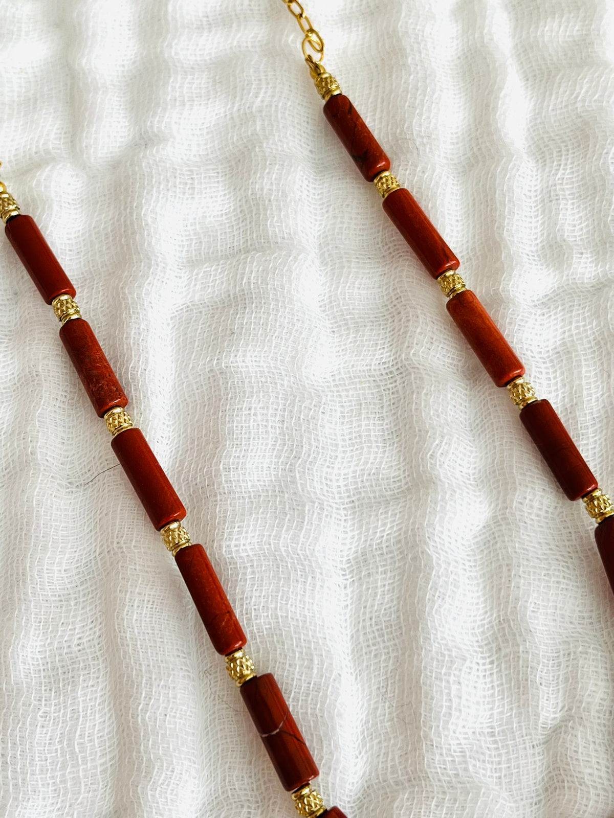 Collier fantaisie fait main.
Chaîne en acier doré et perles tubes en pierre naturelle jaspe rouge rouille.
Pendentif spirale en acier inox doré.
Bijou fait main.
