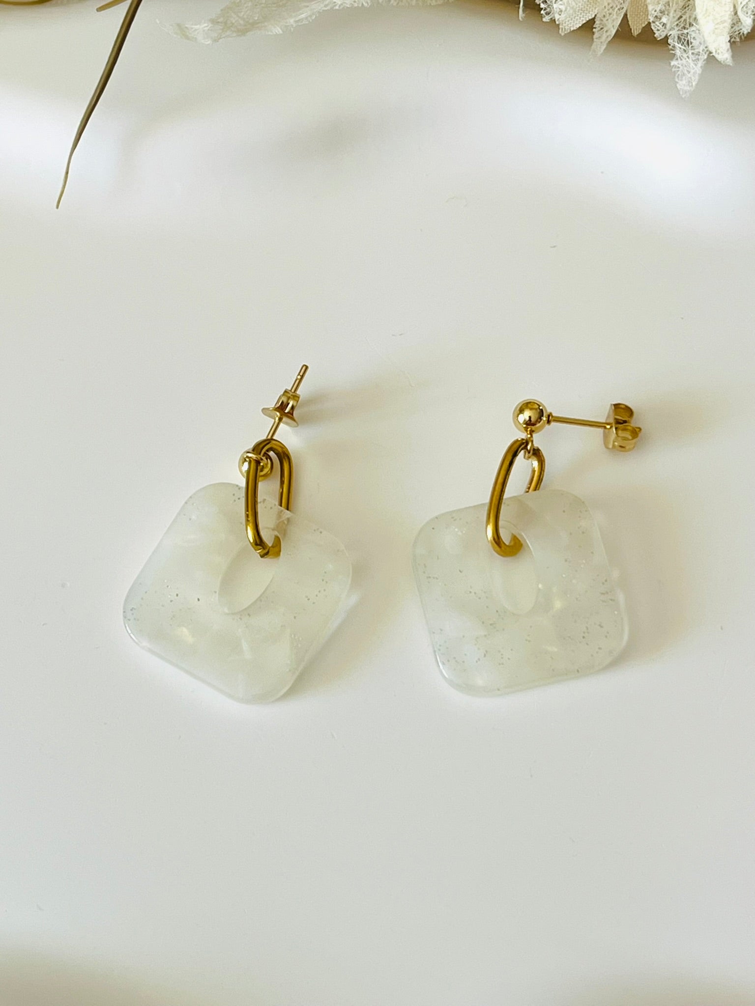 Boucles d'oreilles fantaisie fait main.
Clous d'oreilles en acier doré. Pendentif carré en acrylique marbré.
Bijou fait main.