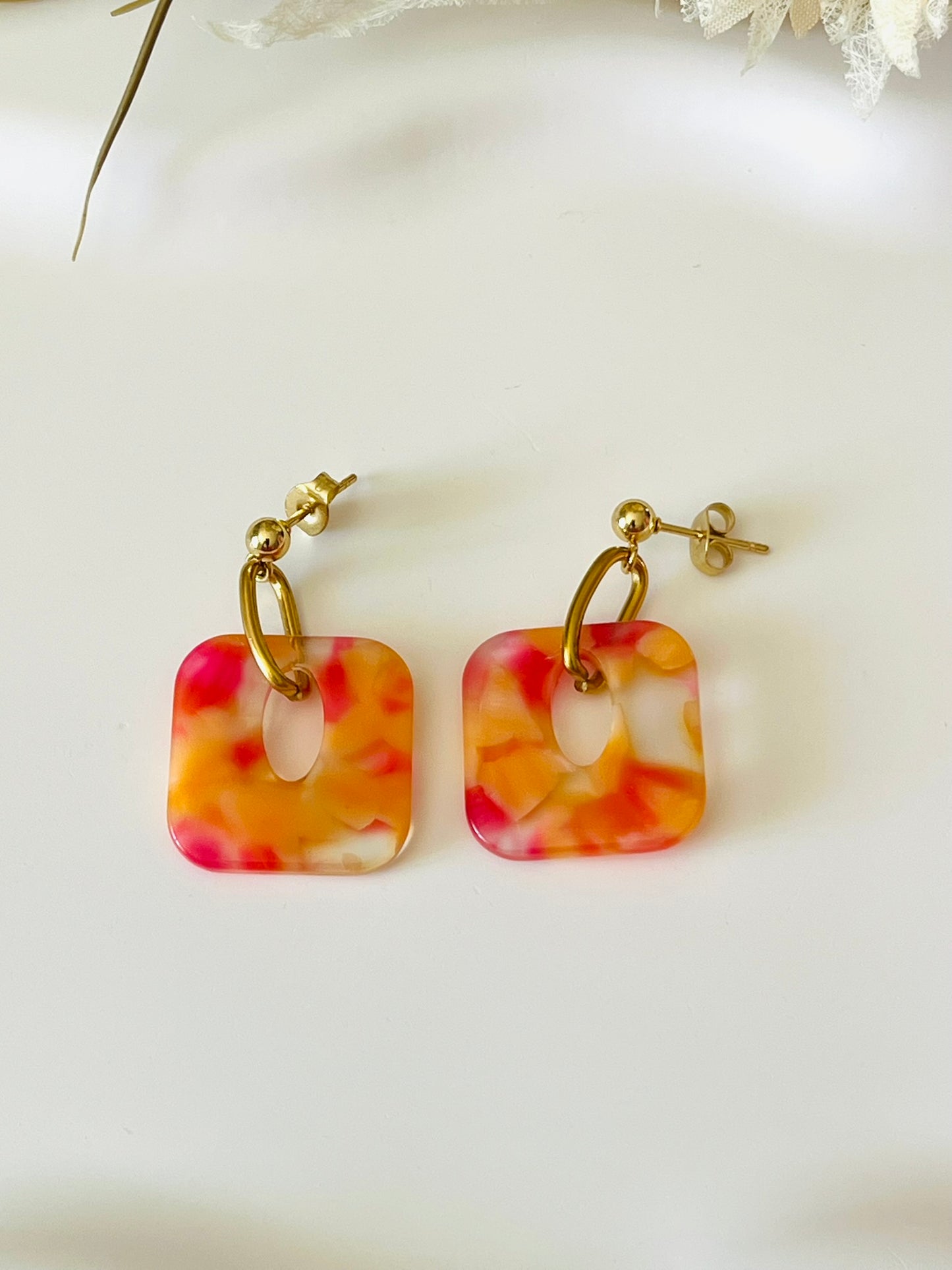 Boucles d'oreilles fantaisie fait main.
Clous d'oreilles en acier doré. Pendentif carré en acrylique marbré.
Bijou fait main.