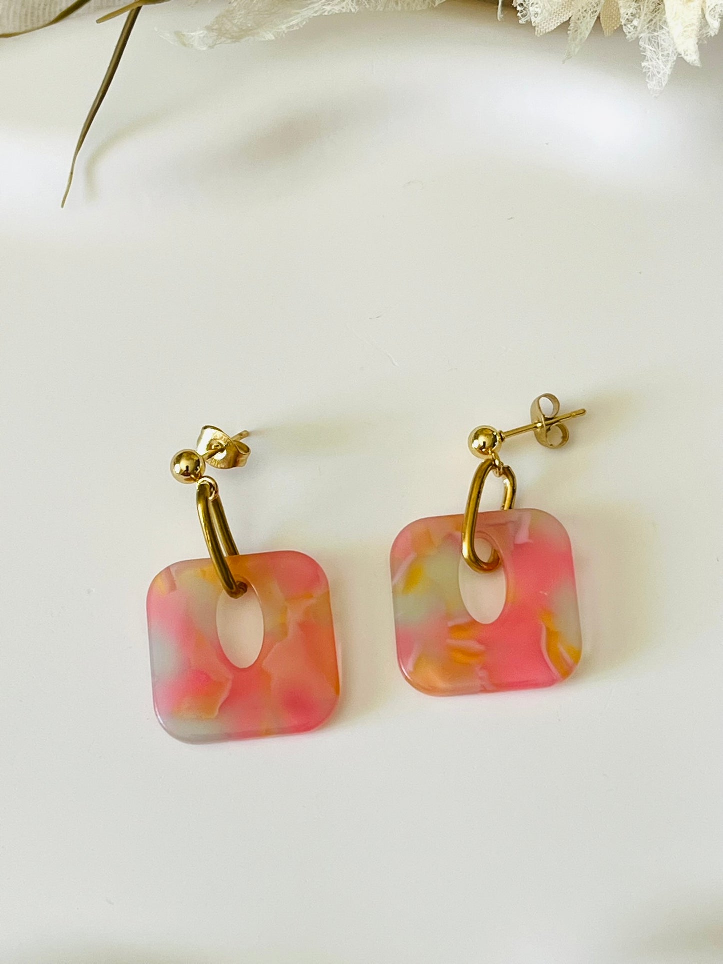 Boucles d'oreilles fantaisie fait main.
Clous d'oreilles en acier doré. Pendentif carré en acrylique marbré.
Bijou fait main.
